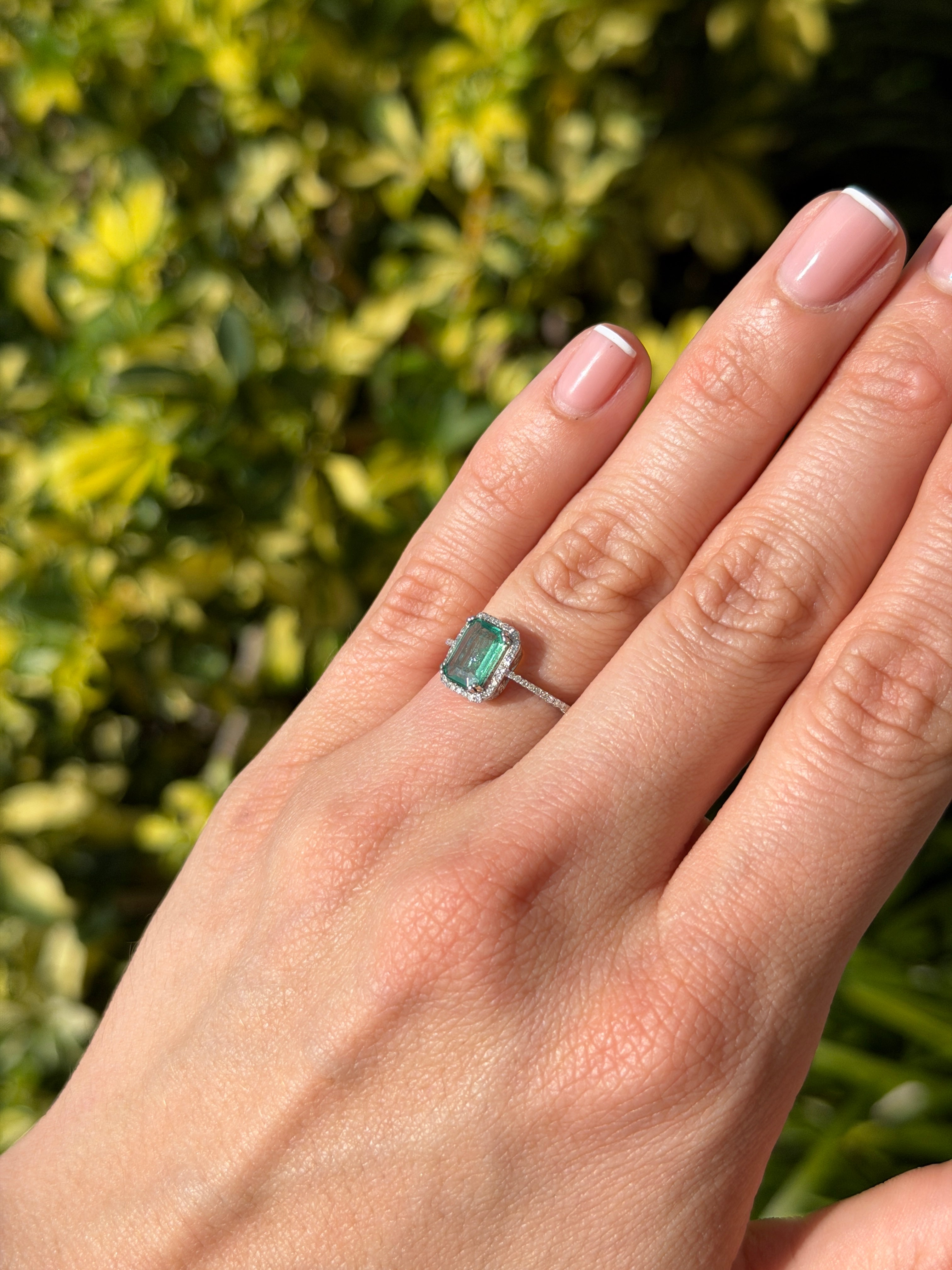 10x7.5mm emerald and diamond halo engagement ring in 14K white gold by JR Colombian Emeralds, featuring a clear emerald center.