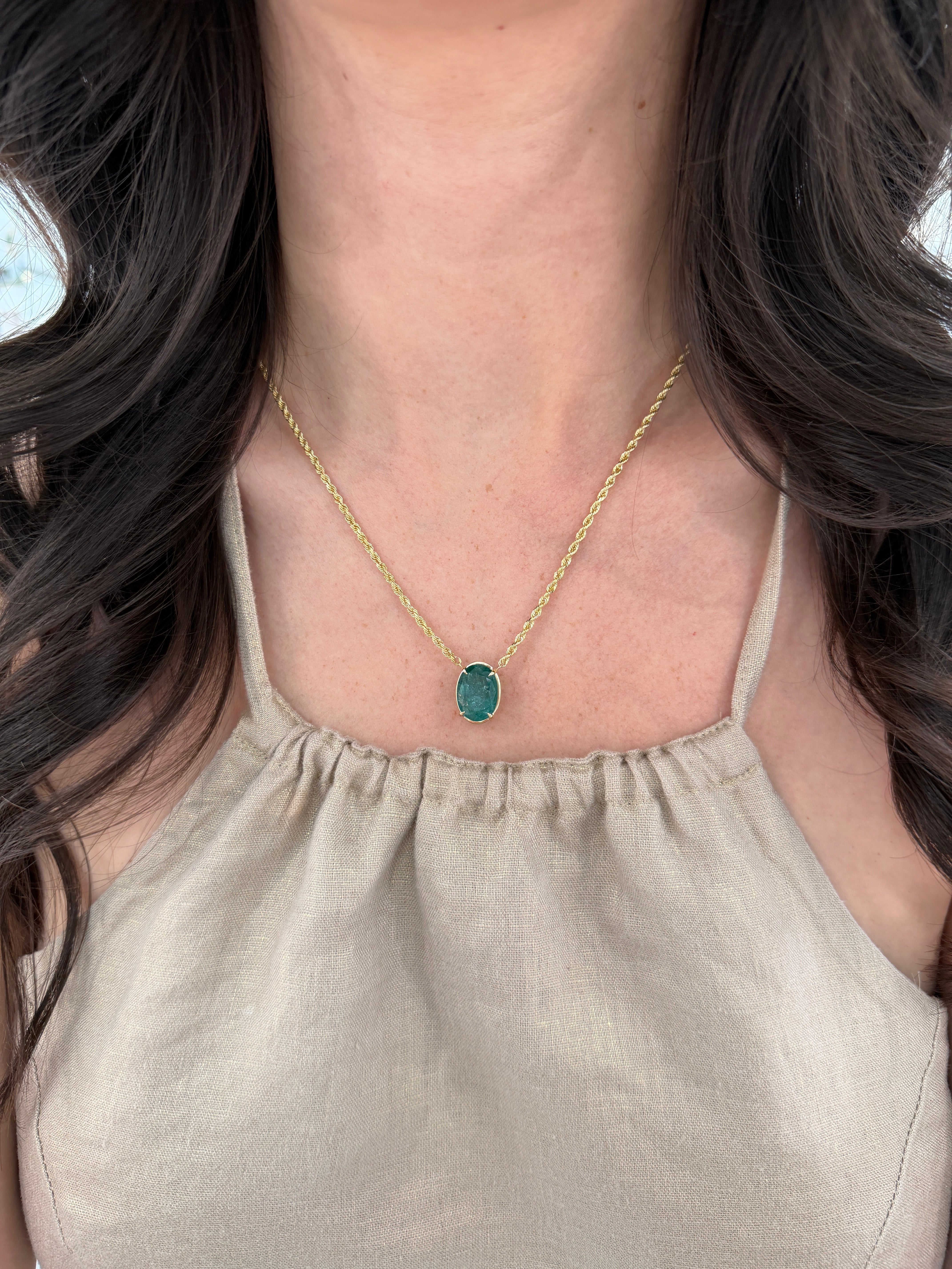 9 Carat oval emerald solitaire necklace in 14K yellow gold, featuring a stunning green emerald pendant on a delicate chain.