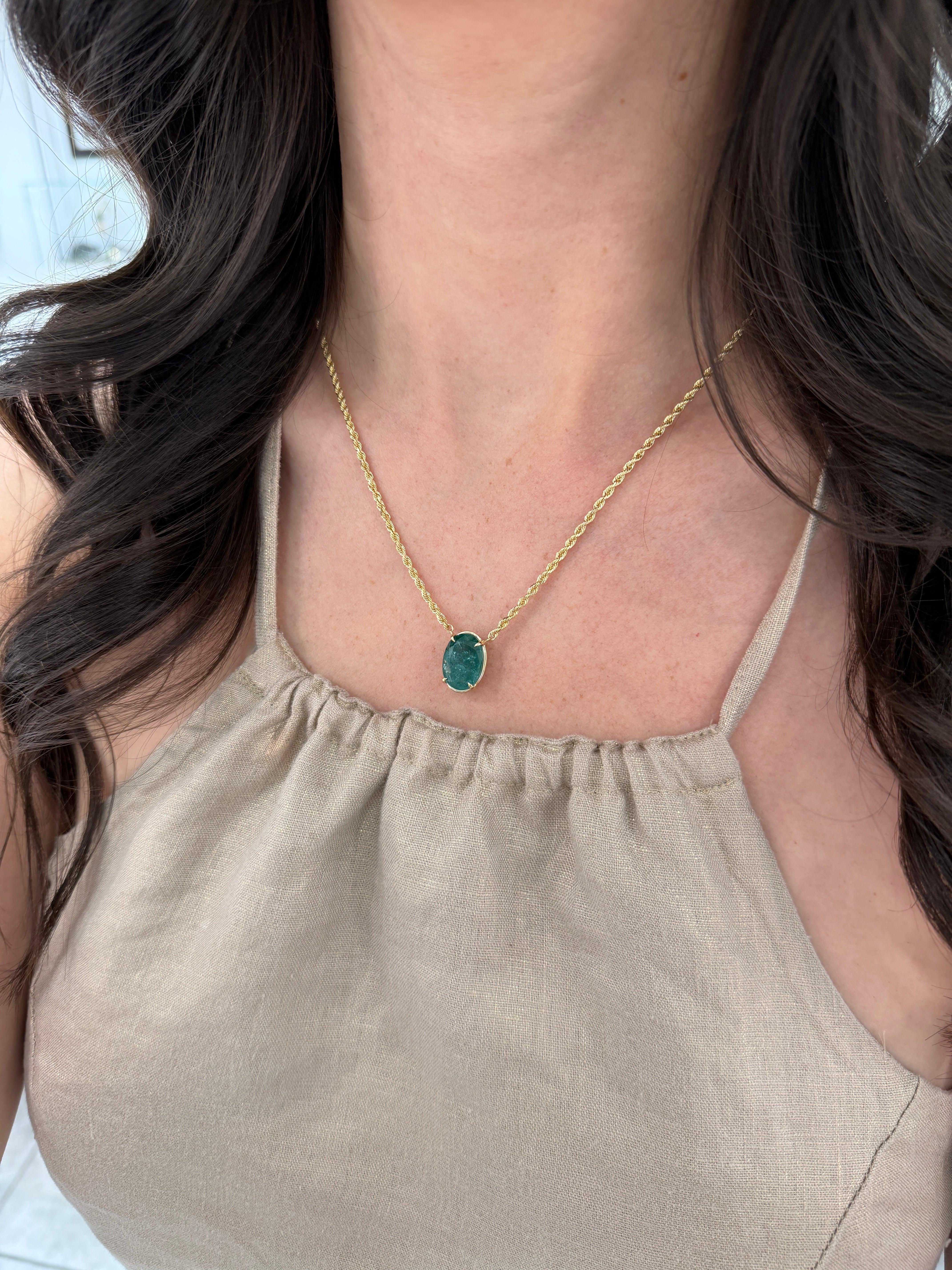 9 carat oval emerald solitaire necklace in 14K yellow gold, featuring a green emerald gemstone on a delicate chain.