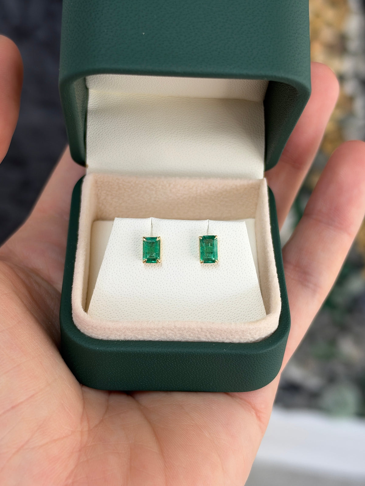 Medium green Zambian emerald cut stud earrings with 1.0 tcw in 14K gold by JR Colombian Emeralds, showcasing the sparkling gemstones.