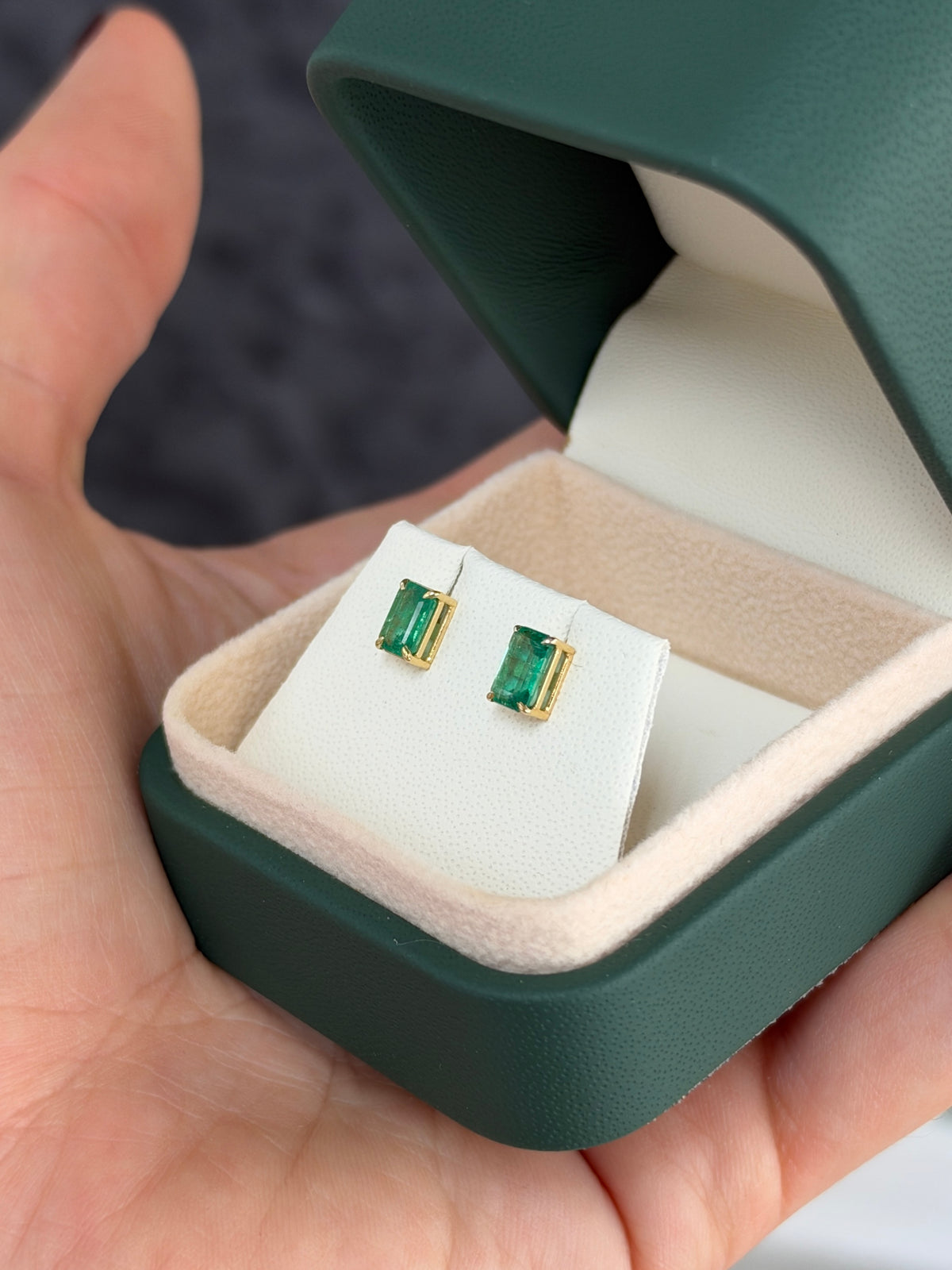 Medium green Zambian emerald cut stud earrings with 1.0tcw, set in 14K gold, featuring elegant gemstone detail.