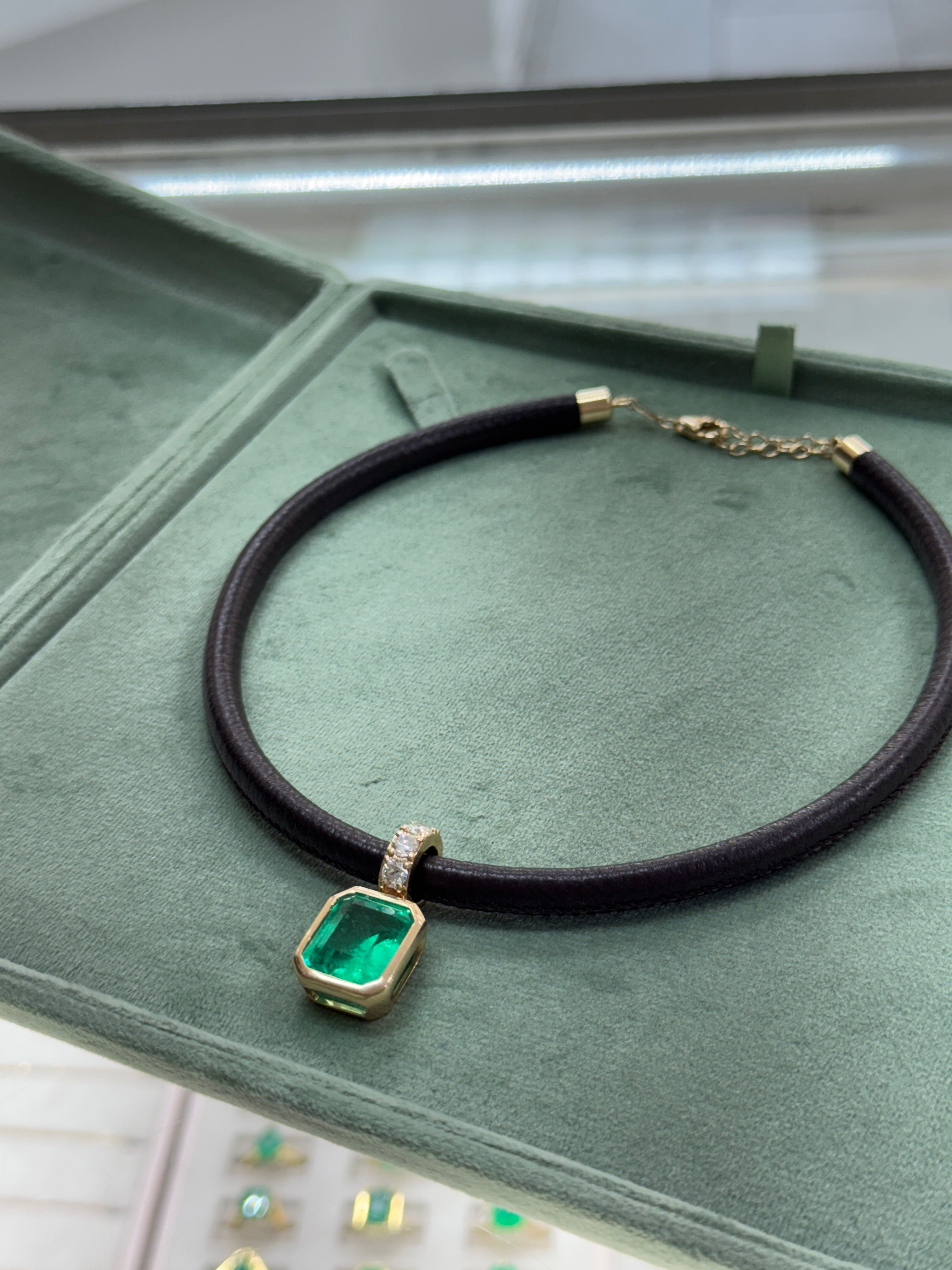 Ciondolo con smeraldo colombiano e diamanti incastonati a castone, 9,22 carati, su cordoncino in pelle color cioccolato, 18 carati