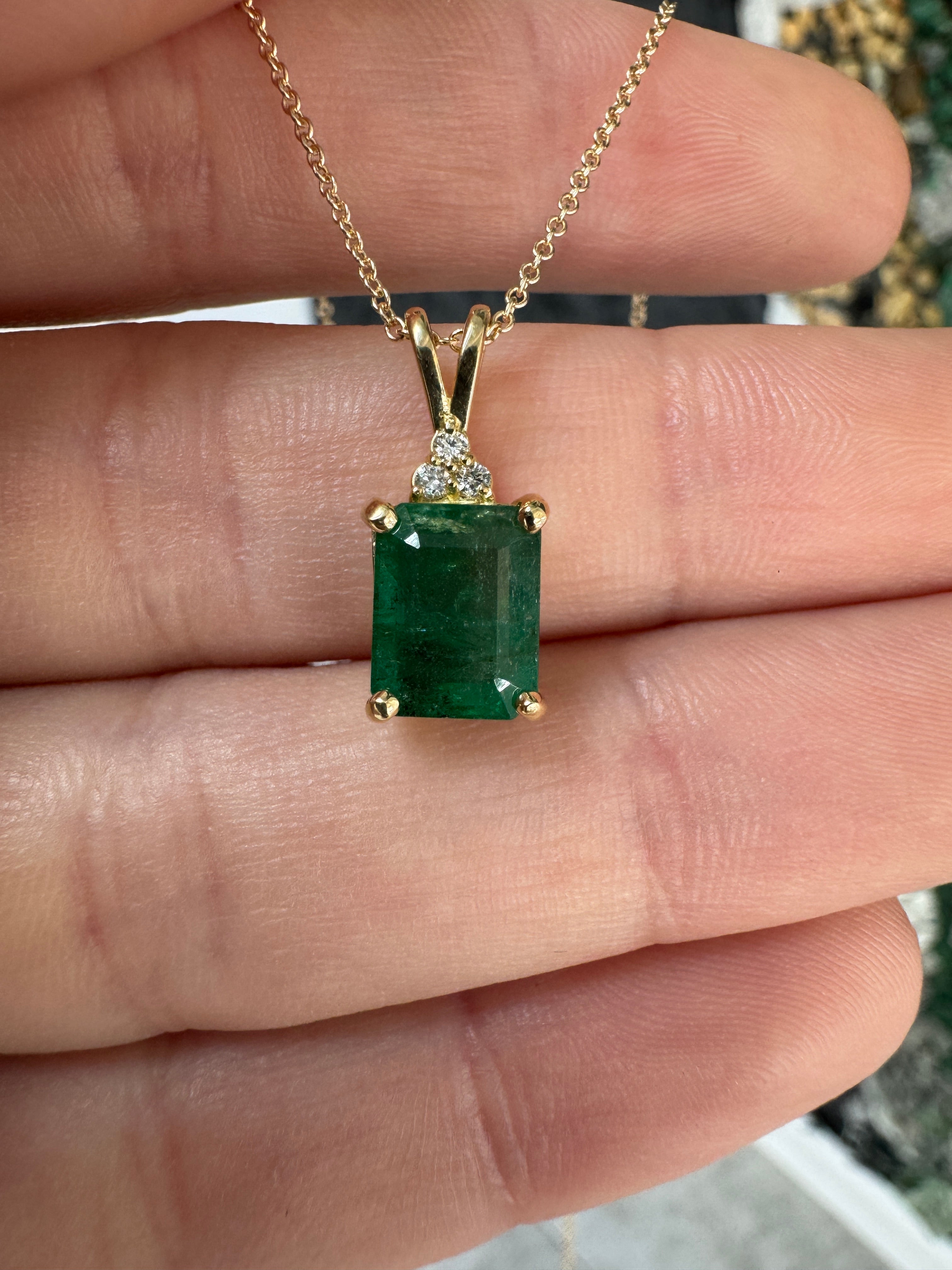 Emerald cut emerald pendant with trefoil diamond accents in 14K gold, featuring a 2.75 carat Colombian emerald and diamond details.