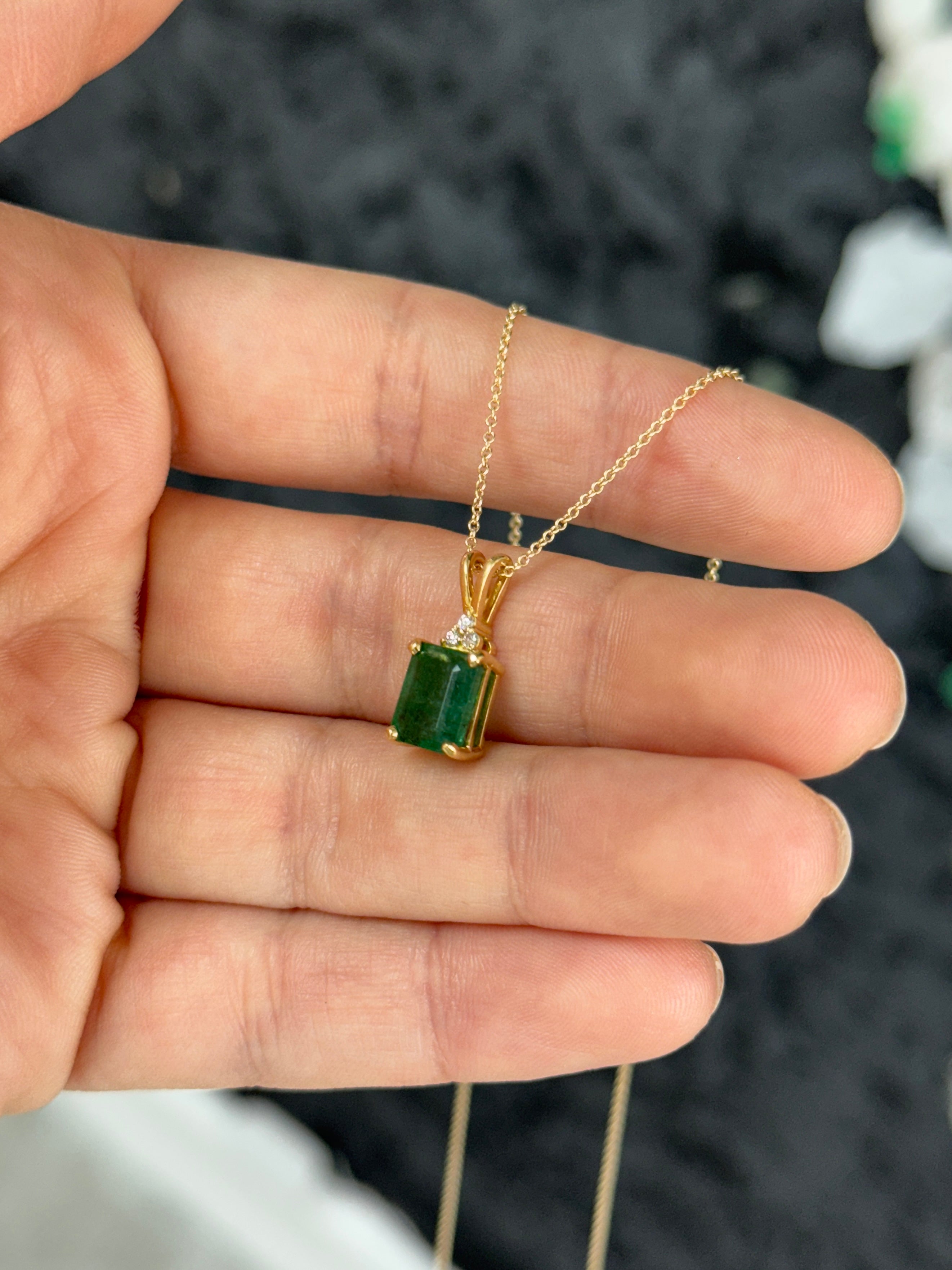 Emerald cut emerald pendant with trefoil diamond accents in 14K gold, featuring a 2.75-carat Colombian emerald stone.