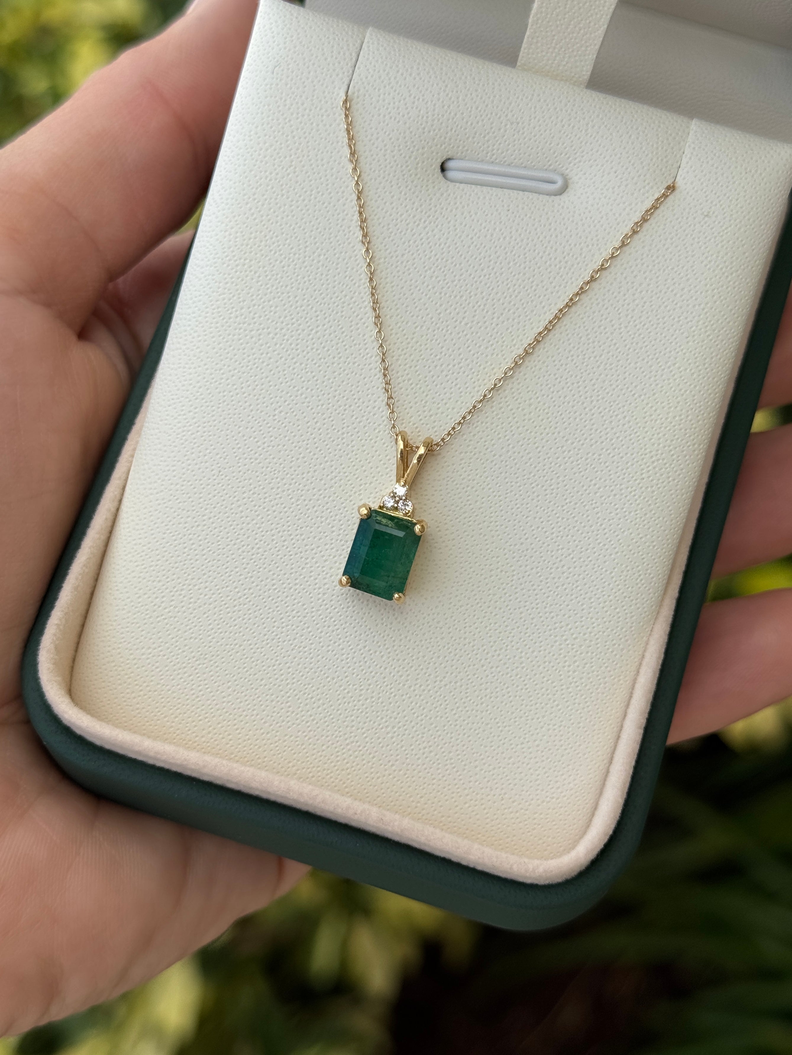 Emerald cut emerald pendant with trefoil diamond accents in 14K gold from JR Colombian Emeralds.