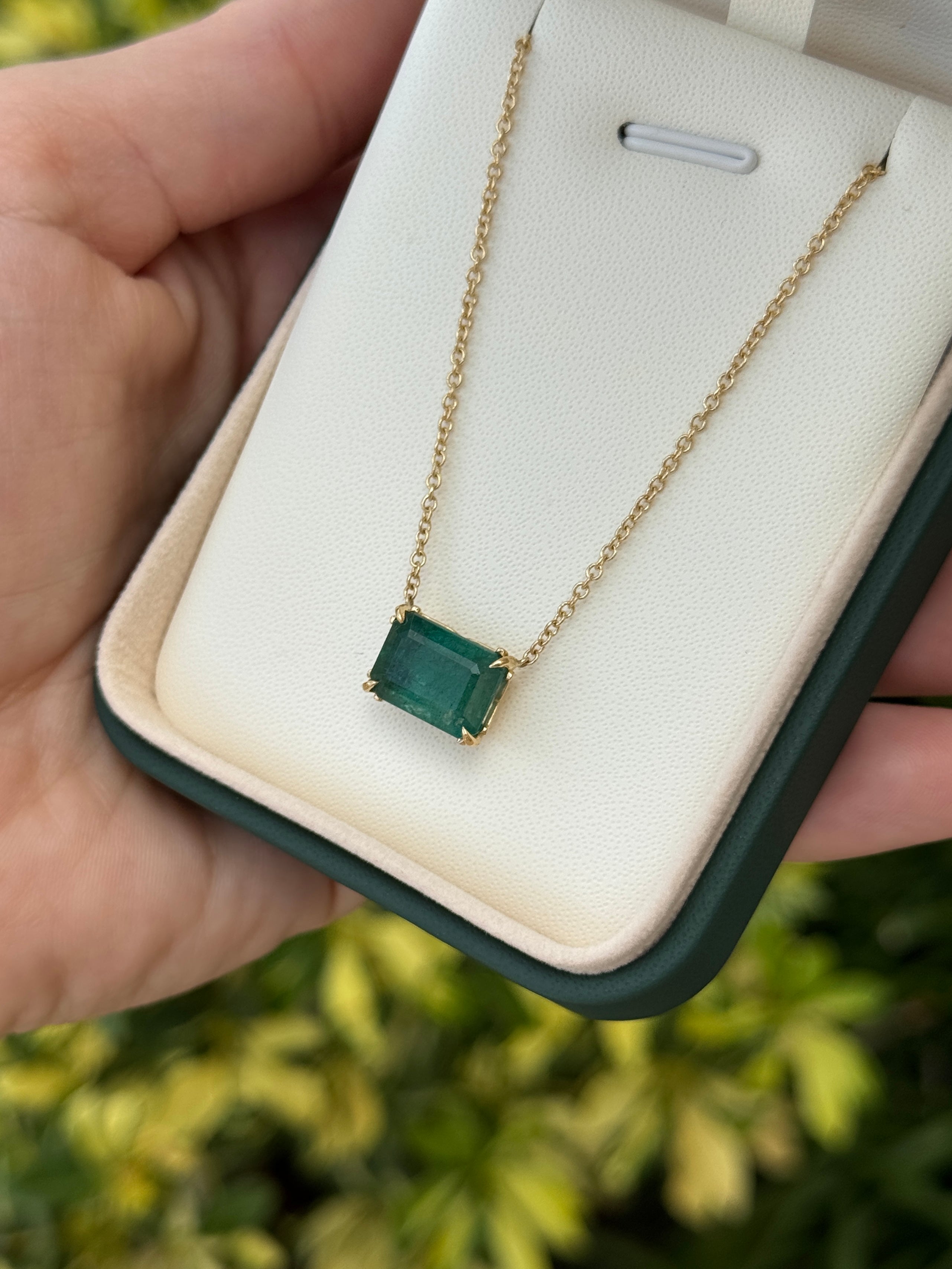 18K gold emerald necklace featuring 5.70ct east-west stationary emerald solitaire with fleur de lis design by JR Colombian Emeralds.