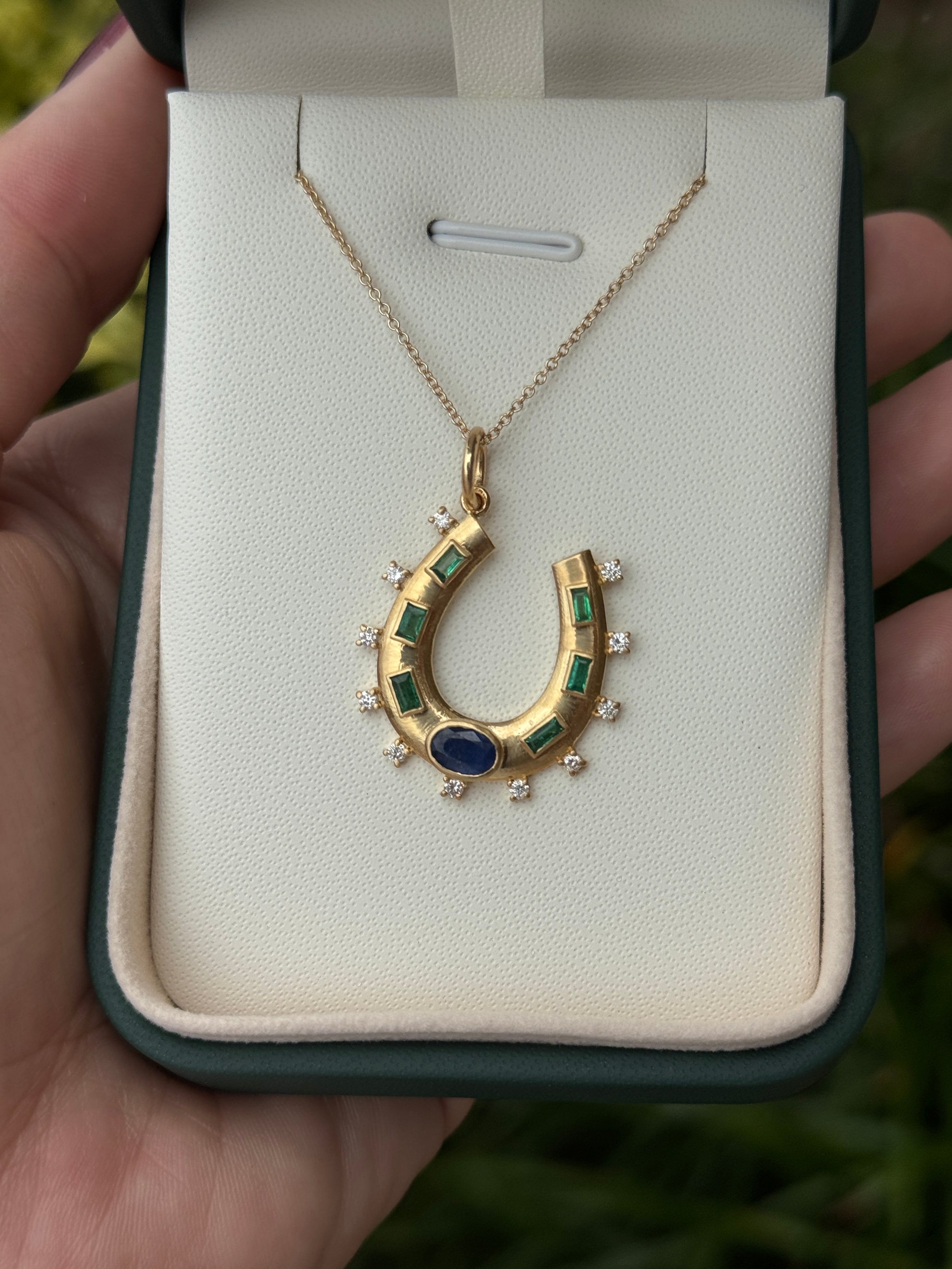 14K gold horseshoe charm pendant with 1.26tcw natural sapphire, emerald, and diamond accents, showcasing fine jewelry craftsmanship.