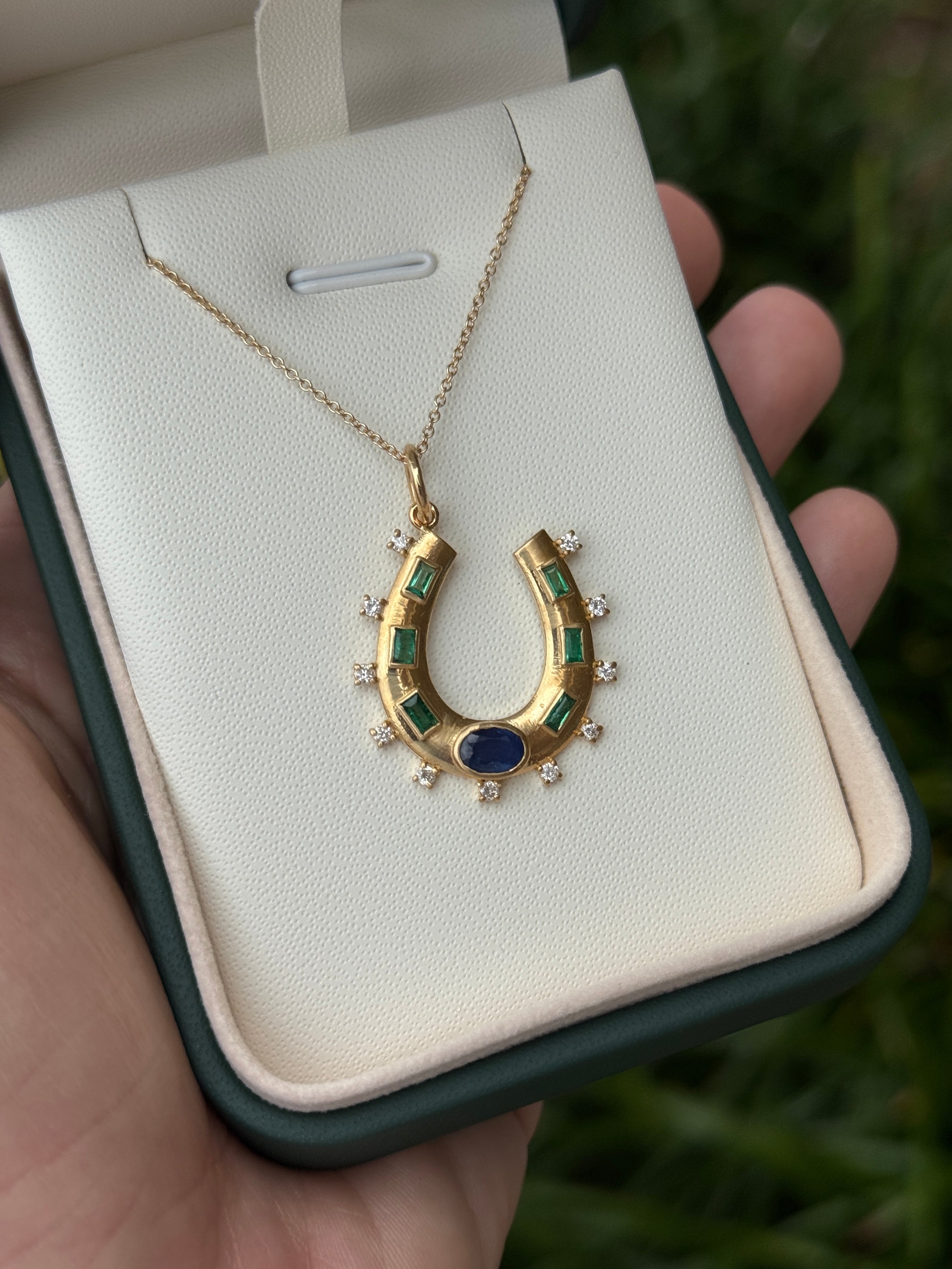14K gold horseshoe charm pendant with 1.26tcw natural sapphires, emeralds, and diamonds, featuring a detailed jewelry design.