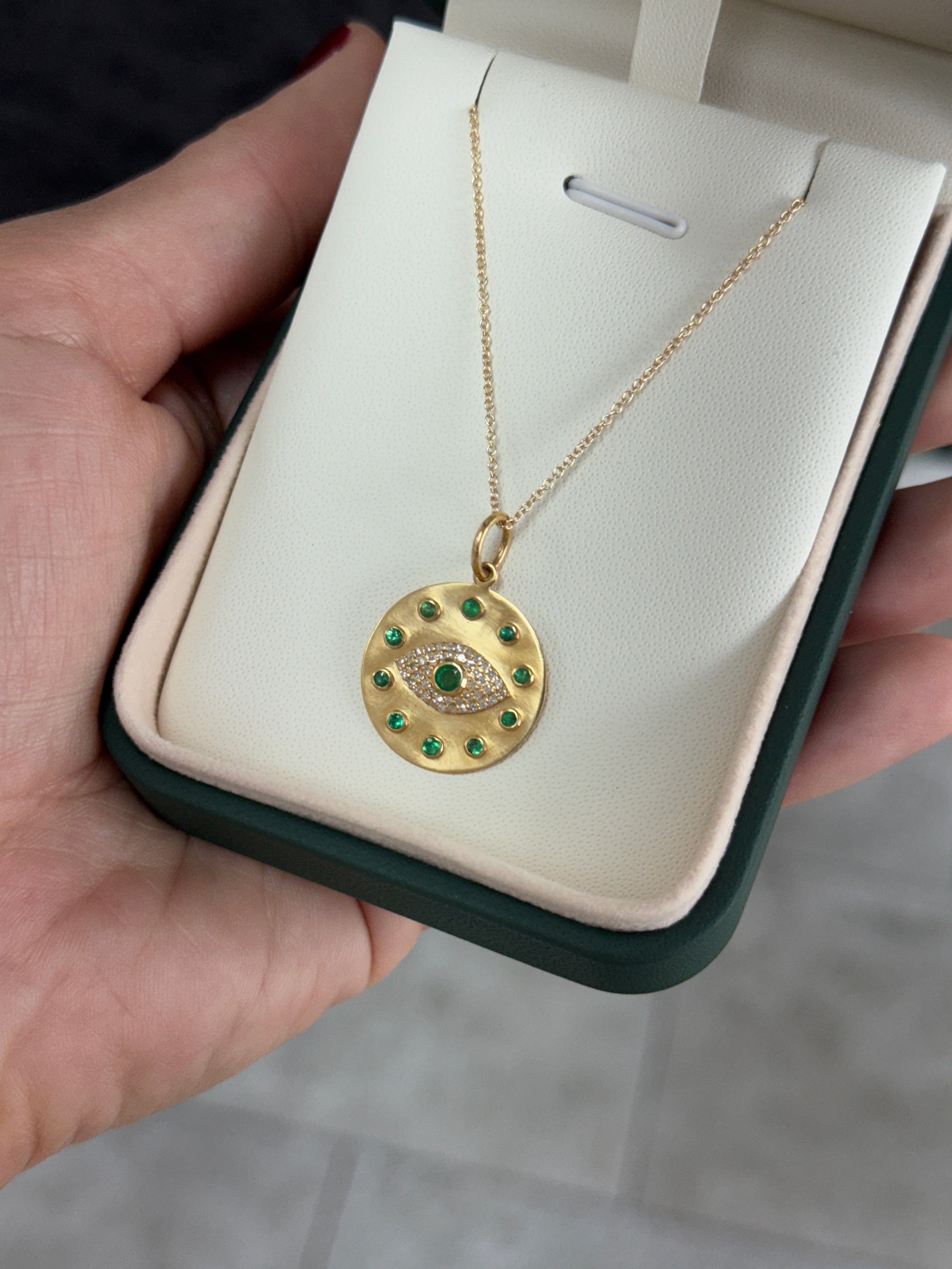 14K natural emerald and diamond evil eye protection charm pendant with intricate design, featuring vibrant green emeralds and sparkling diamonds.