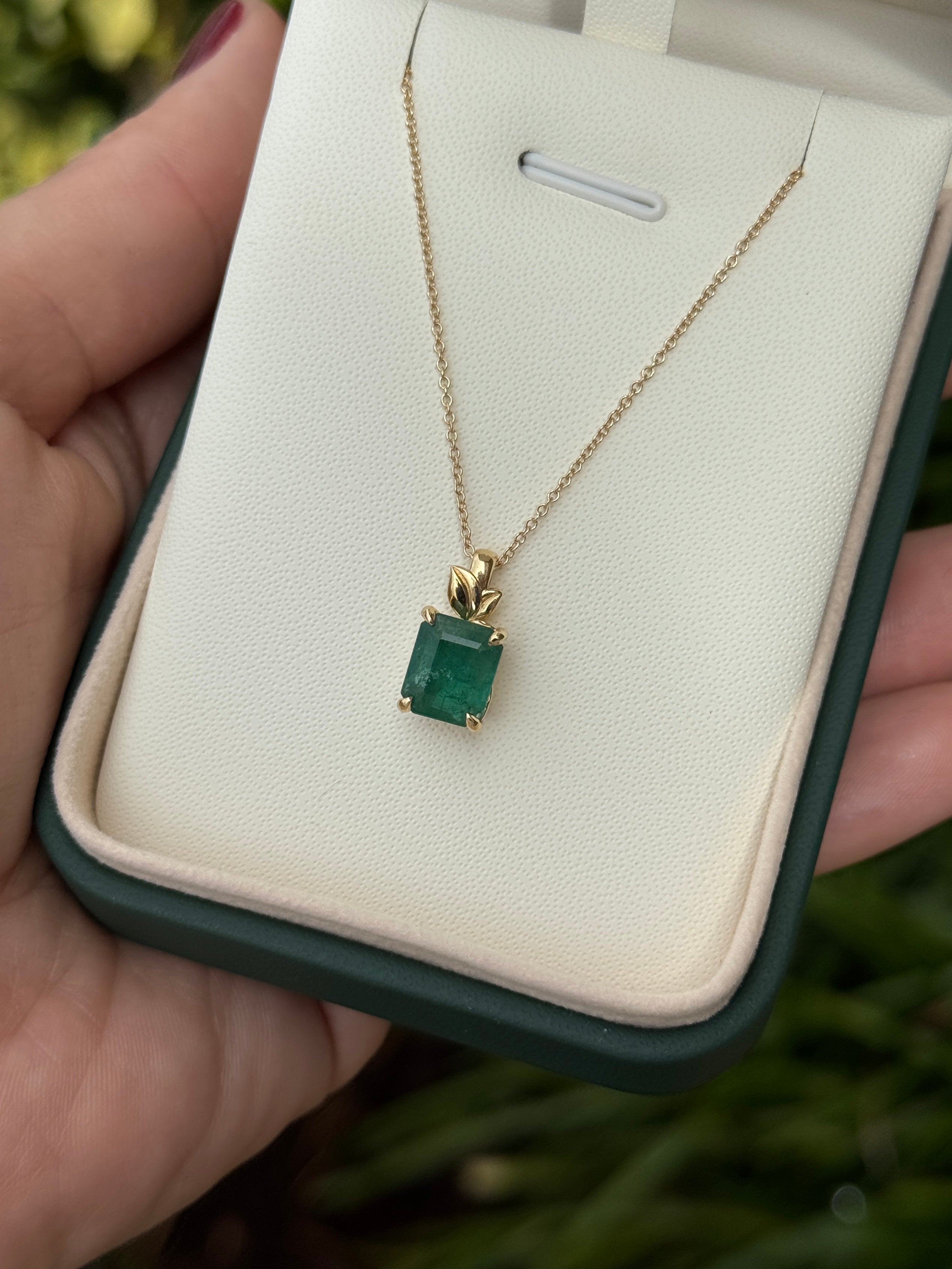 Emerald cut emerald pendant with leaf design on 14K gold chain, featuring natural-inspired style from JR Colombian Emeralds.