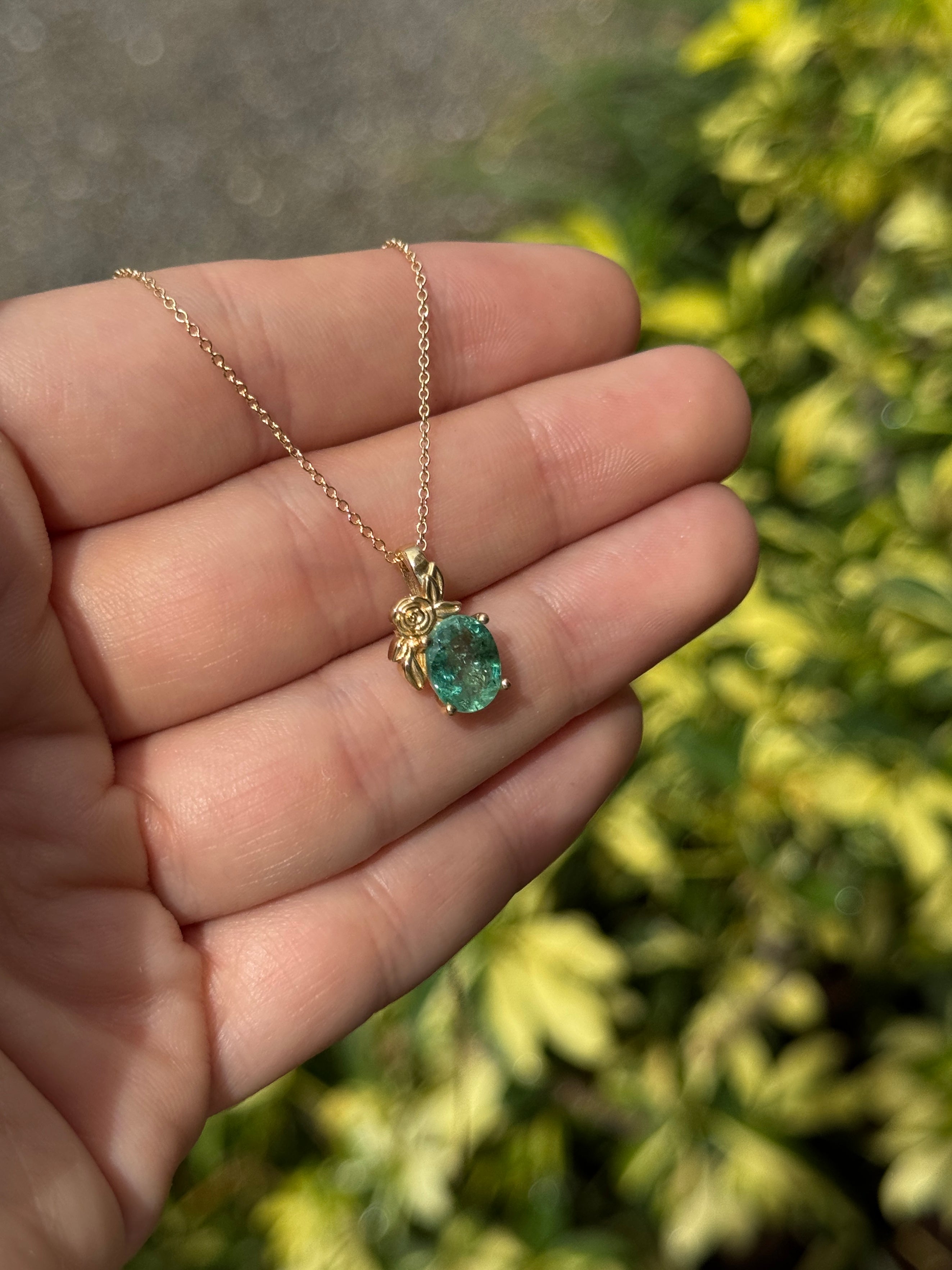 Collana con pendente in oro 14 carati con uno smeraldo naturale verde medio da 1,80 carati, taglio ovale, incastonato in una montatura floreale a solitario.