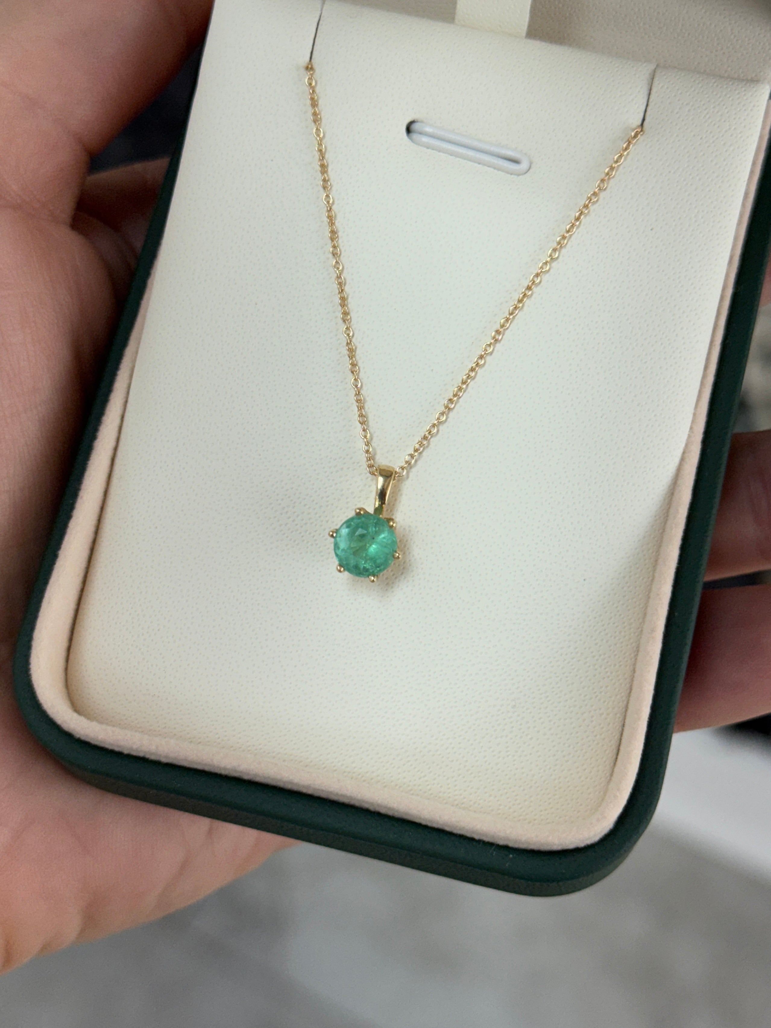 14K gold Tiffany-style emerald solitaire necklace featuring a 1.14ct round emerald gemstone on a delicate chain.