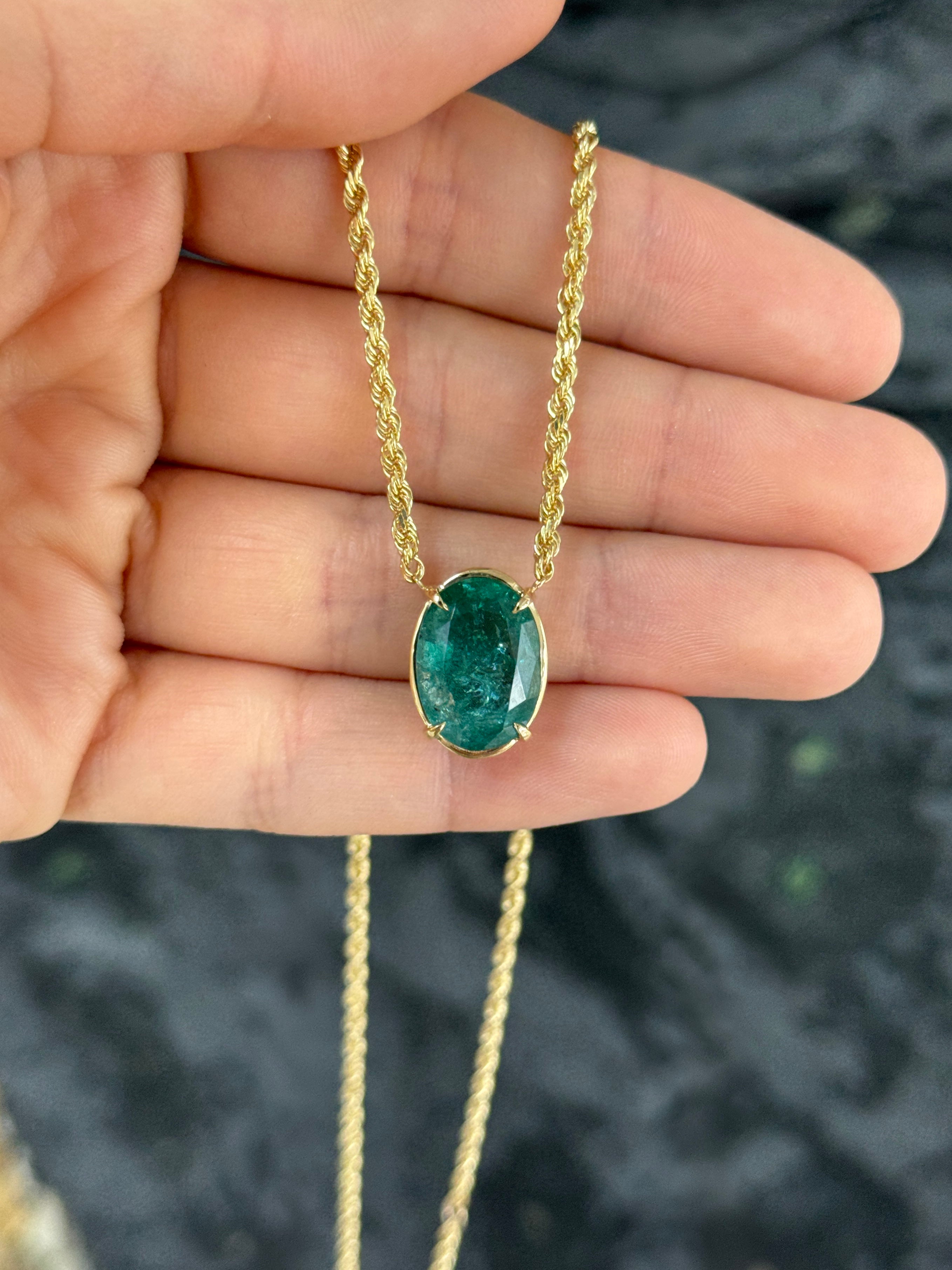 Oval emerald solitaire necklace in 14K yellow gold with a 9-carat gemstone, featuring a classic stationary station style.