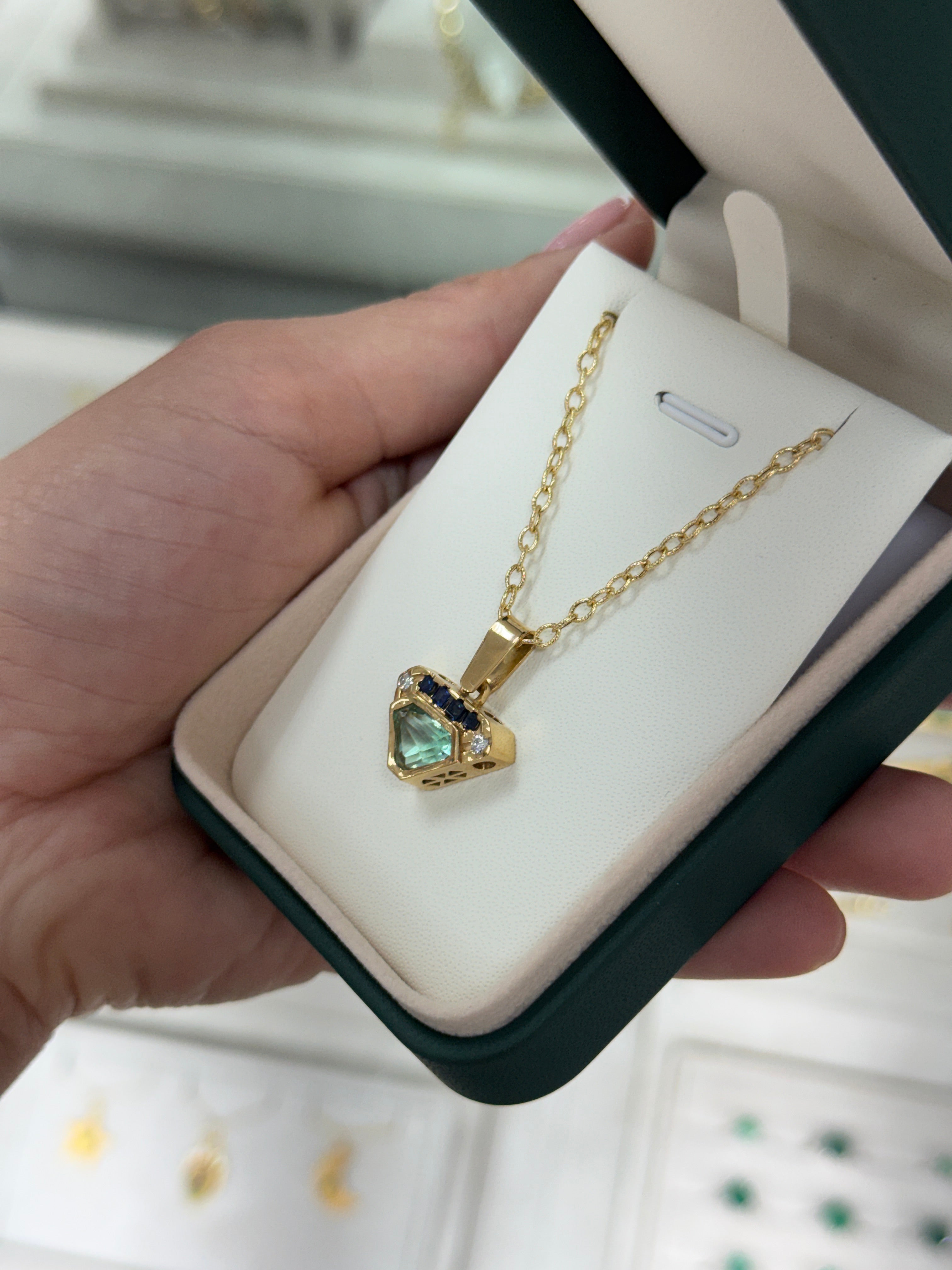 VVS clarity Colombian emerald shield cut pendant with blue sapphire and diamonds from JR Colombian Emeralds.