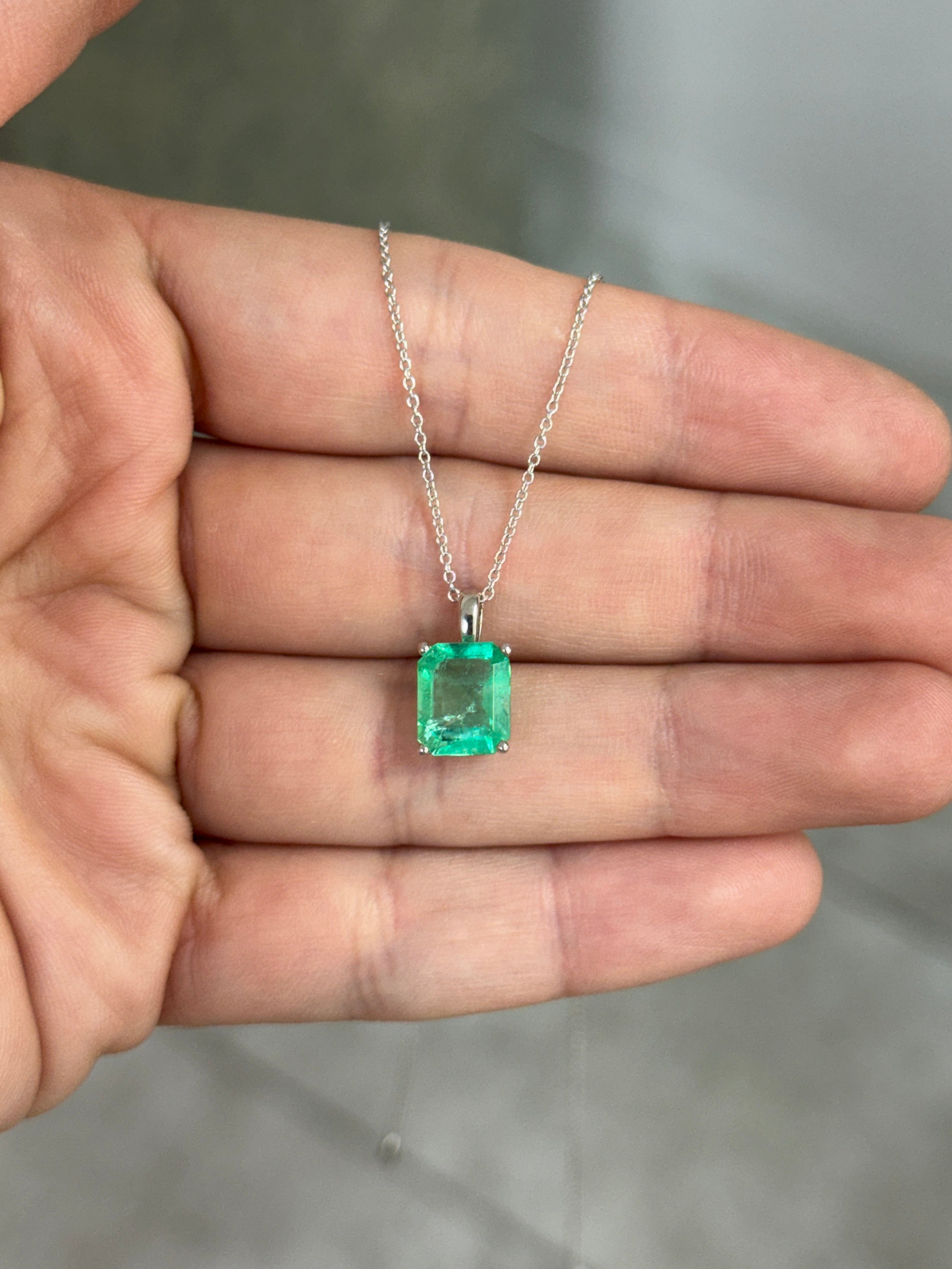 14K white gold Colombian emerald solitaire necklace featuring a 2.51 carat emerald pendant with intricate gold setting.