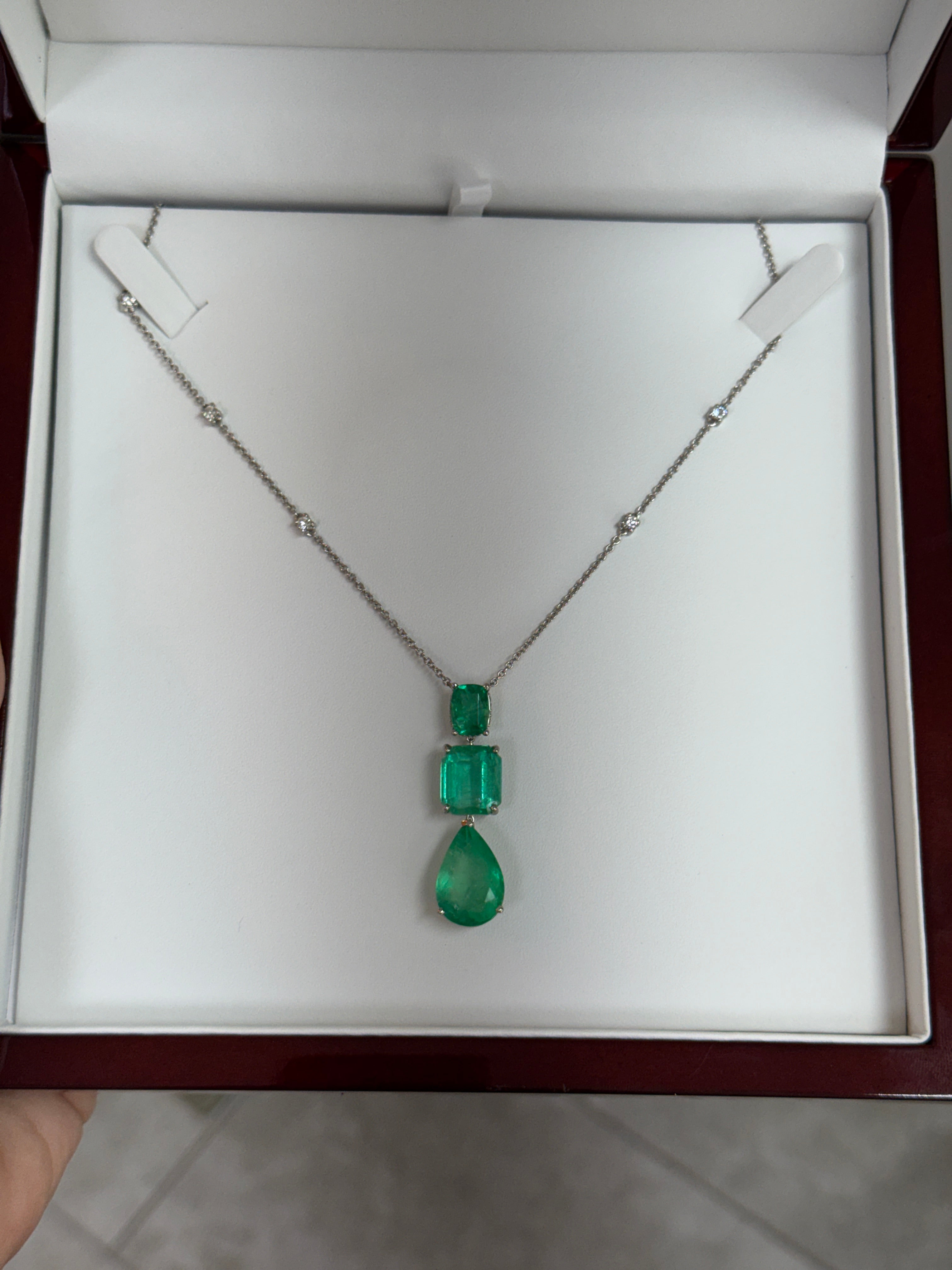Colombian emerald and diamond by-the-yard necklace with cushion and pear-shaped emerald cuts in platinum, showcasing vibrant green gemstones.