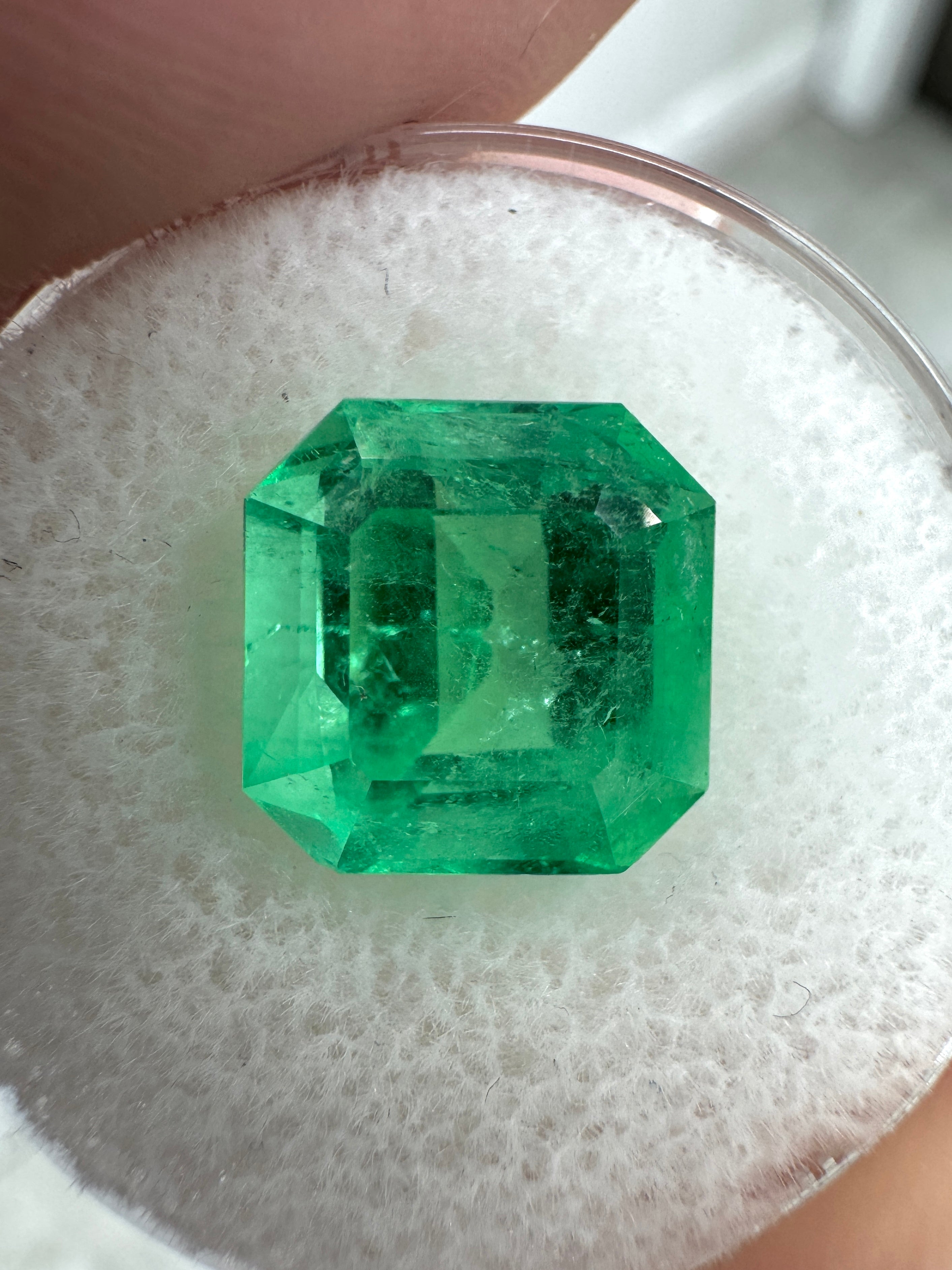 4.57 carat Colombian emerald Asscher cut with clipped corners, glowing and vibrant, set in a jewelry setting by JR Colombian Emeralds