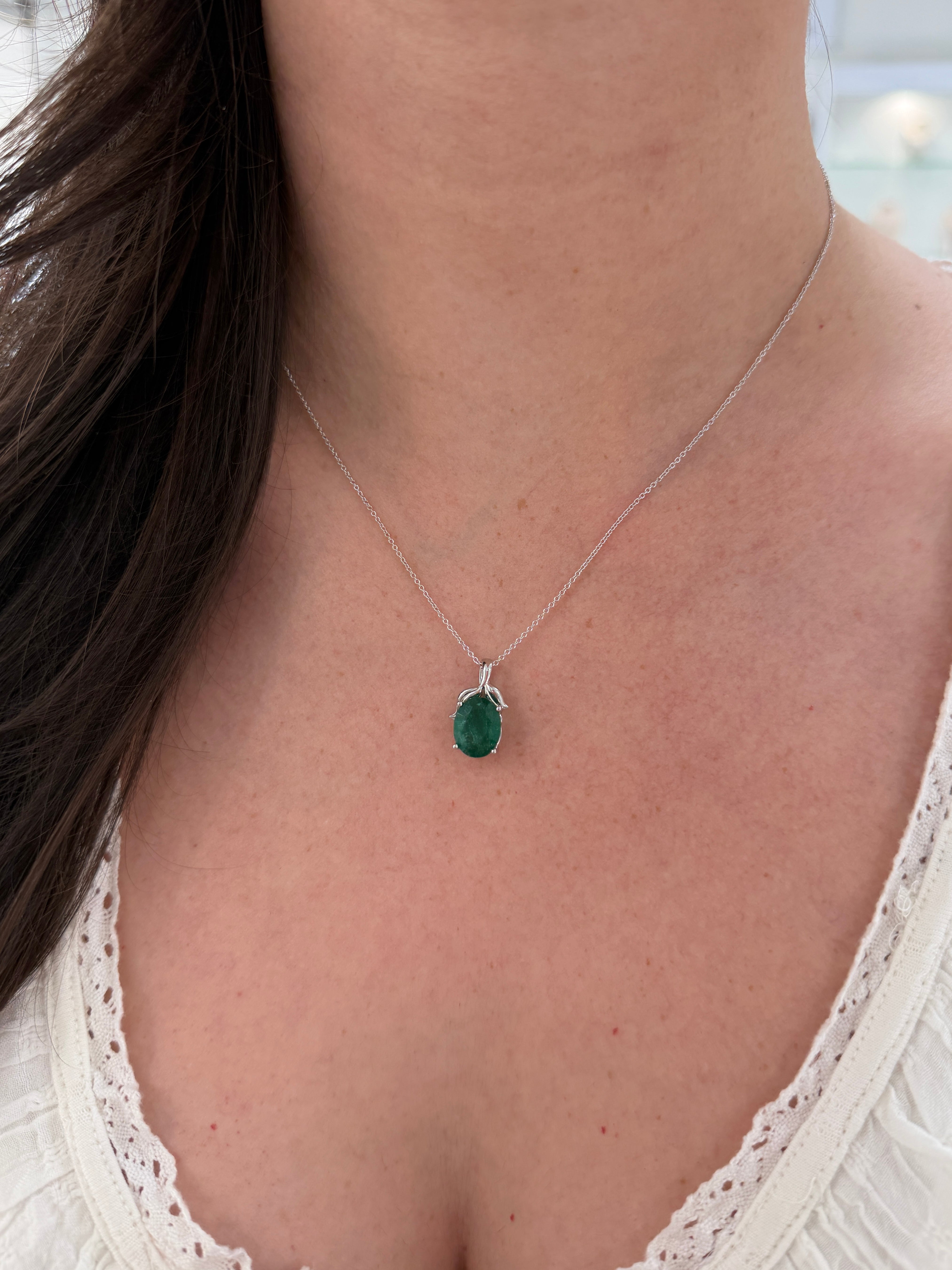 3.23 carat oval cut emerald pendant with leaf bail, platinum necklace, nature-inspired design by JR Colombian Emeralds.