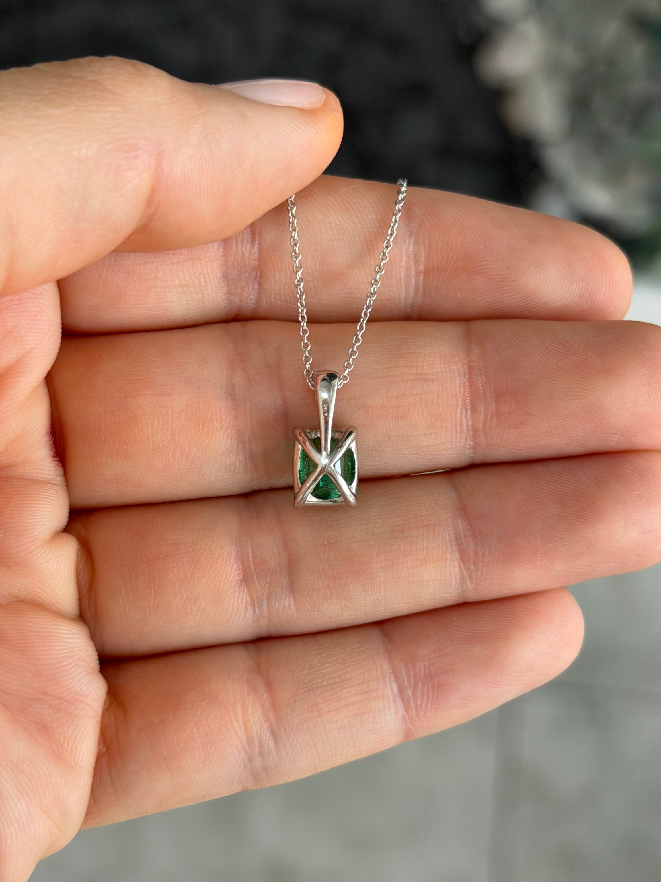 Emerald cut emerald and diamond bail pendant in 14K white gold with 1.60tcw, featuring a stunning green emerald and sparkling diamonds.