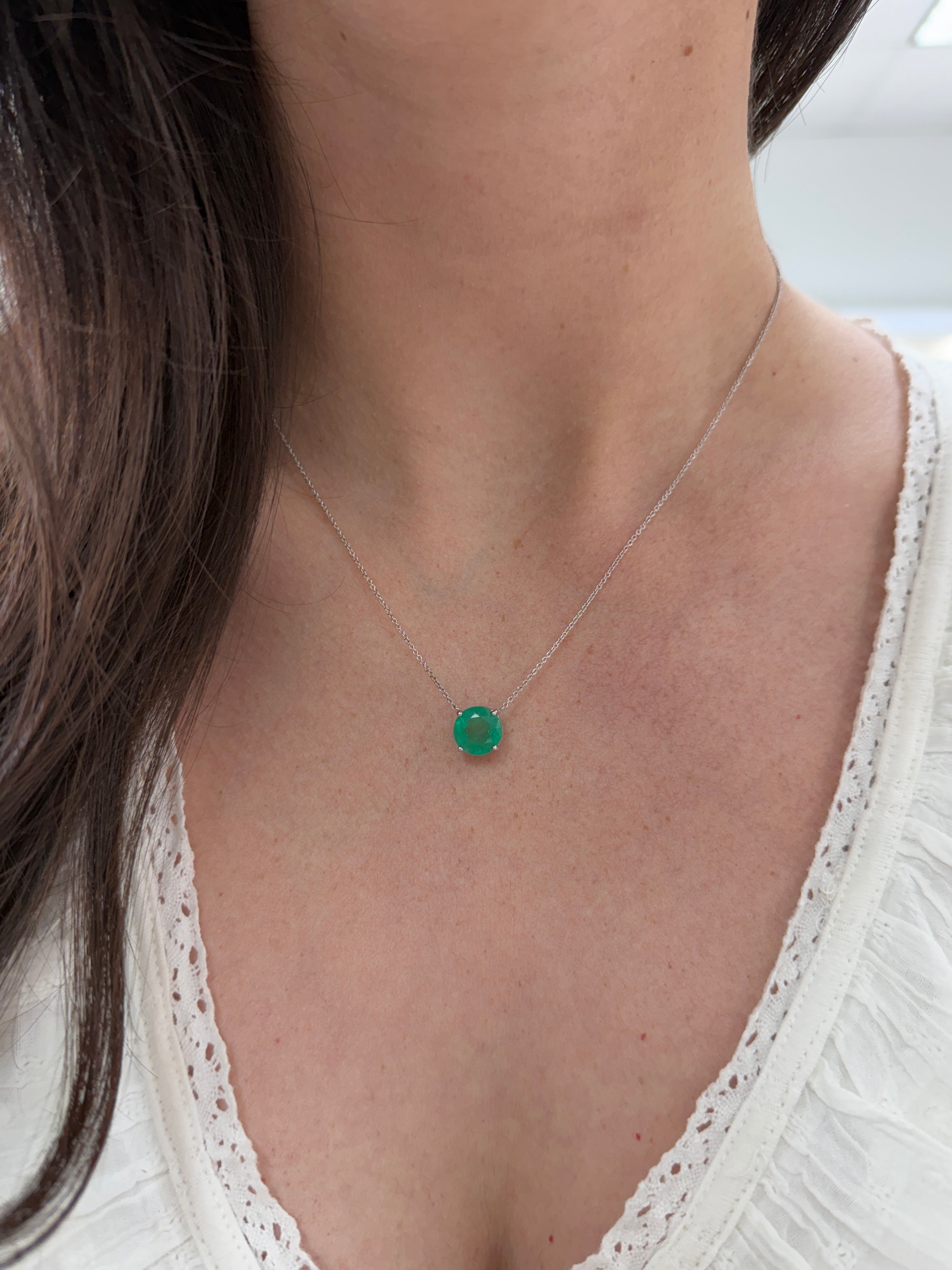 18K gold necklace featuring a 4.45ct round Colombian emerald, showcasing its vibrant green color and elegant design.