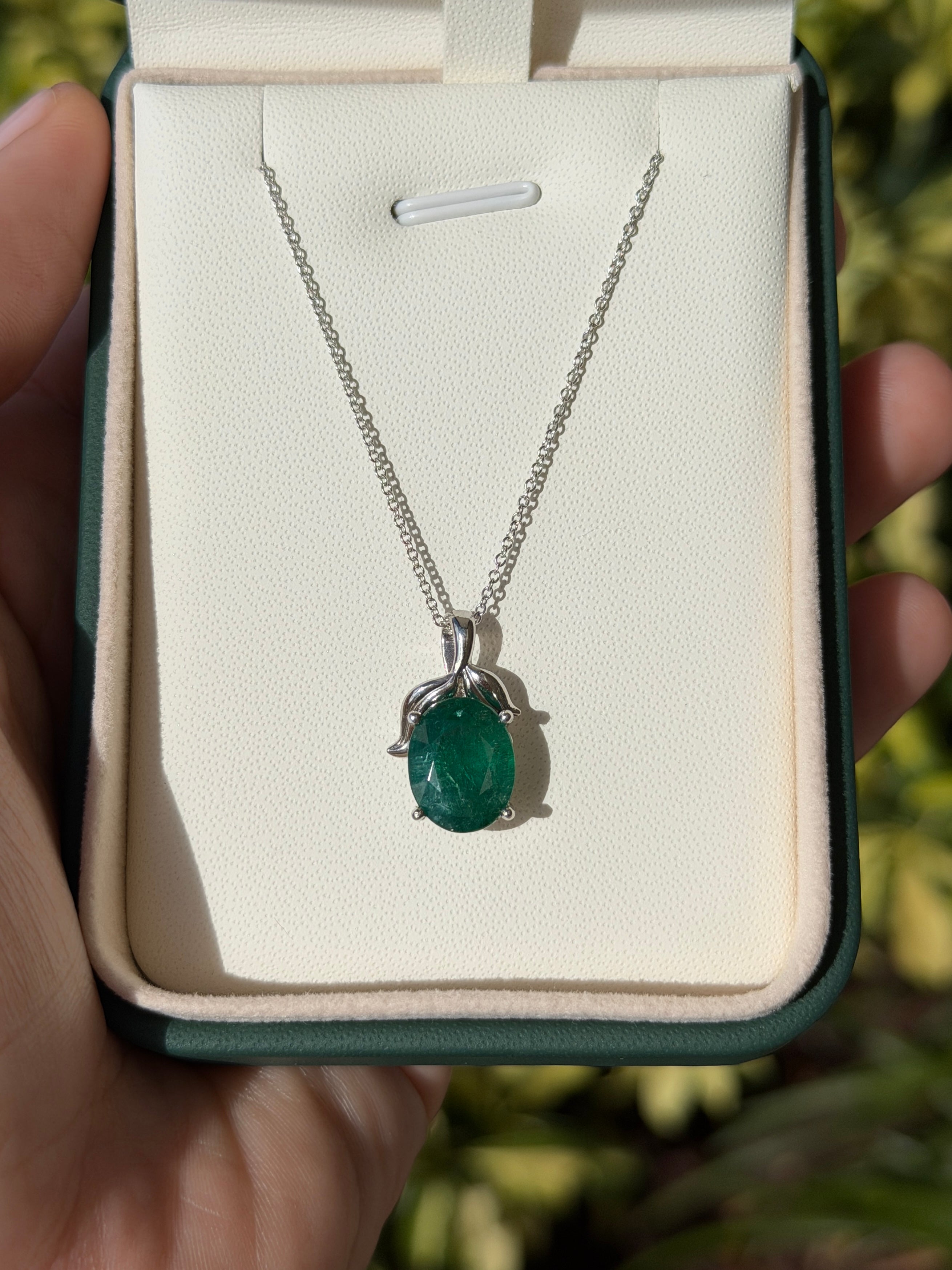 3.23 carat oval cut emerald pendant with leaf design and platinum chain, featuring a nature-inspired emerald necklace by JR Colombian Emeralds.