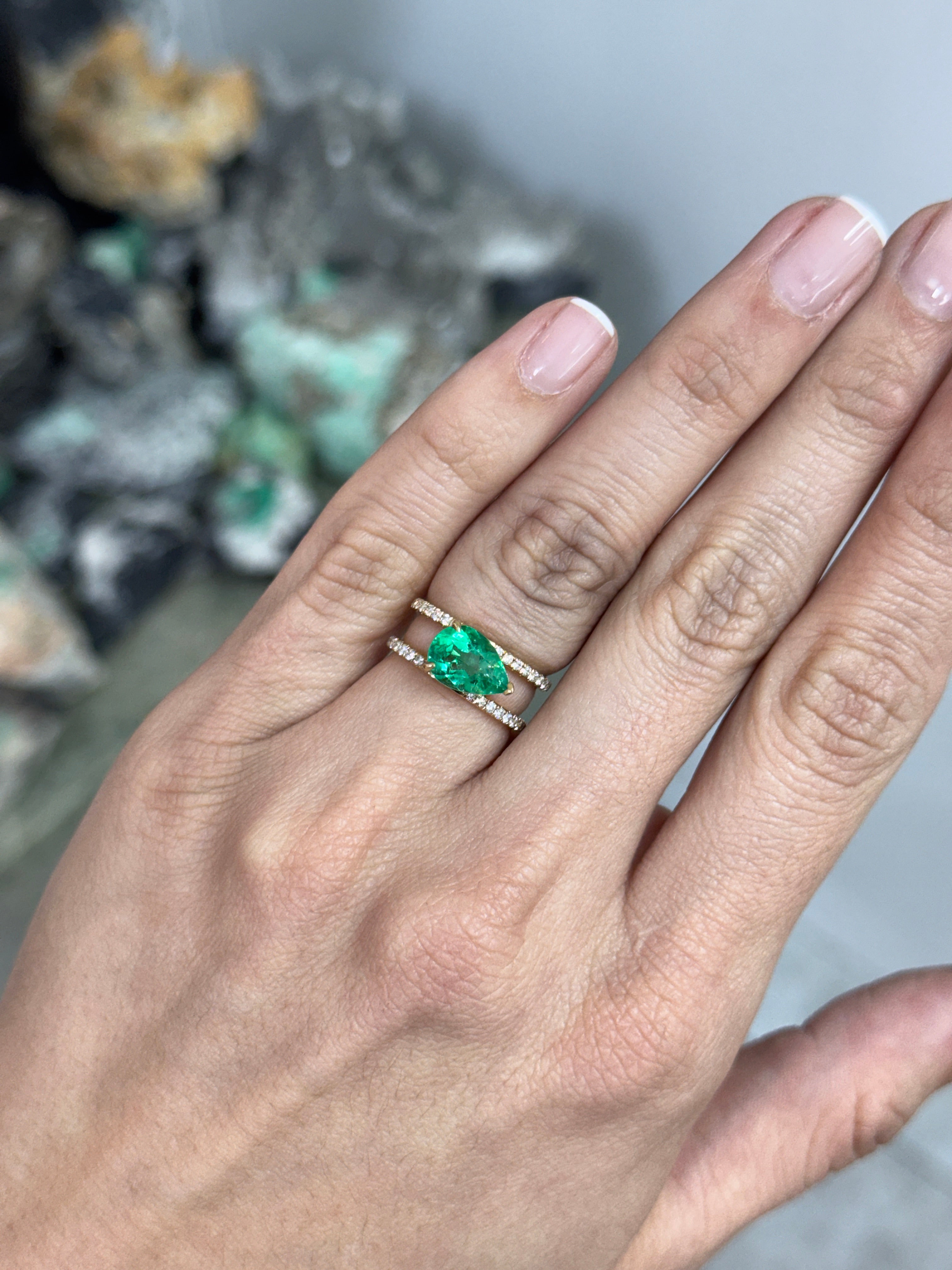 East to West Colombian Emerald and diamond wide band ring in 18K gold, featuring split shank design and 2.29tcw gemstones.