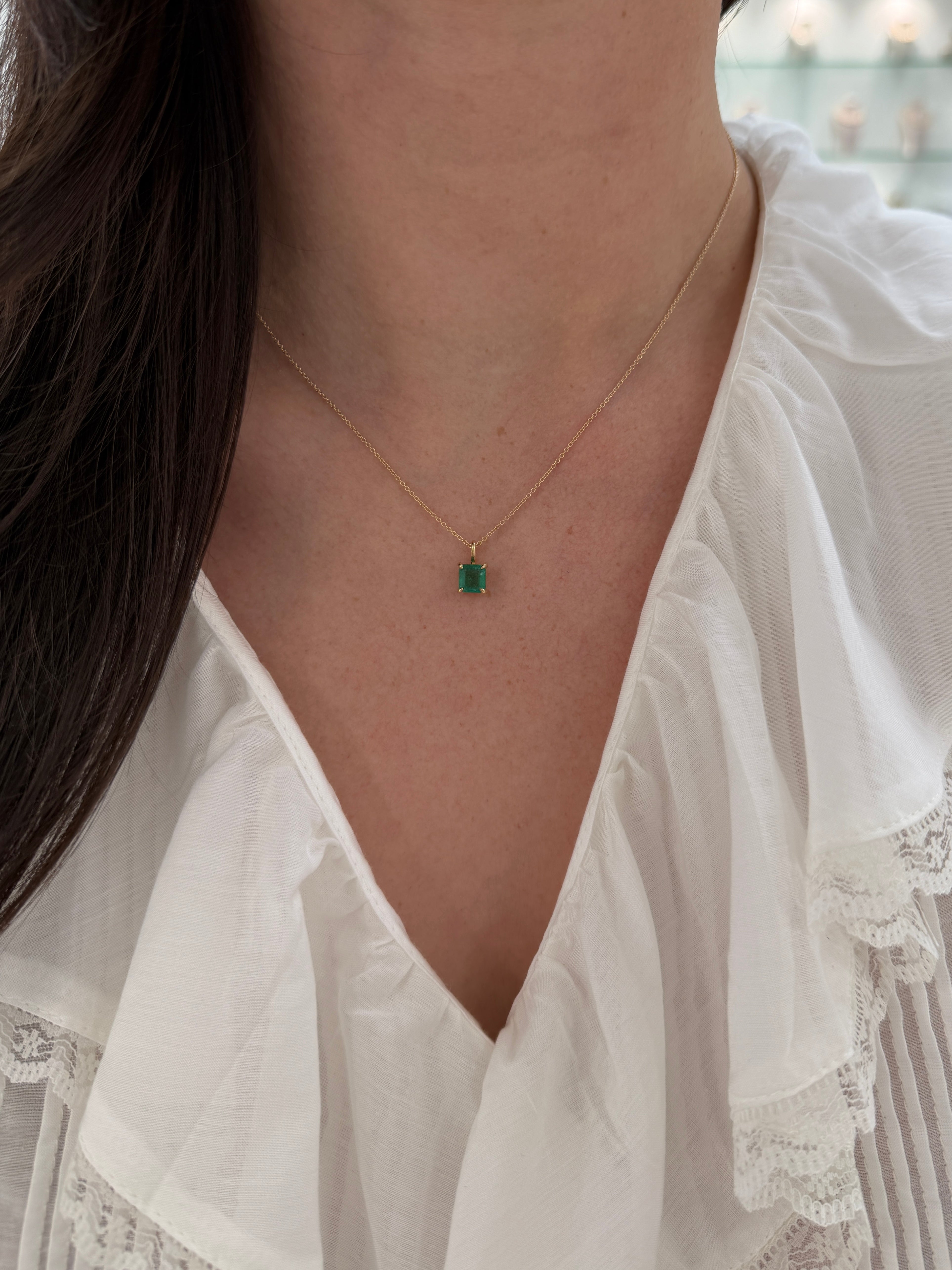 Petite 1.35 Carat Asscher cut emerald solitaire necklace in 14K gold by JR Colombian Emeralds, close-up of the pendant.