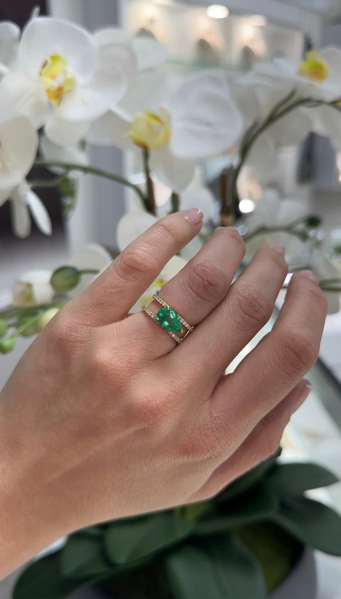 East to West Colombian emerald and diamond wide band ring in 18K gold, featuring a 2.29 tcw emerald and split shank design.