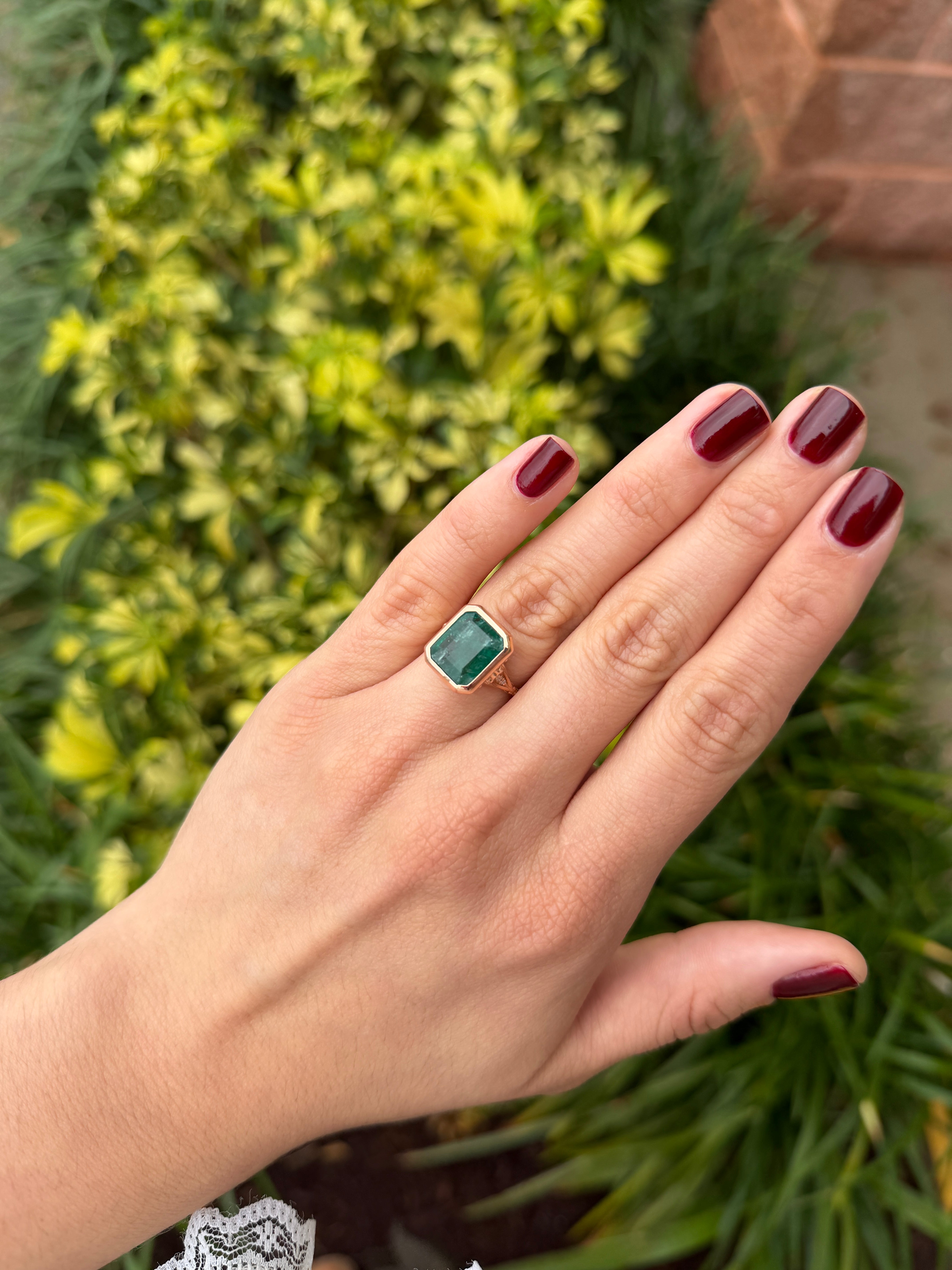 Vintage-inspired 14K rose gold emerald bezel ring with diamond shank and scroll basket detail, by JR Colombian Emeralds.