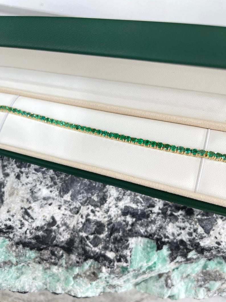 Unisex tennis bracelet with medium dark green round cut emeralds, 14K gold setting, Colombian Emerald brand, 6.0 tcw.