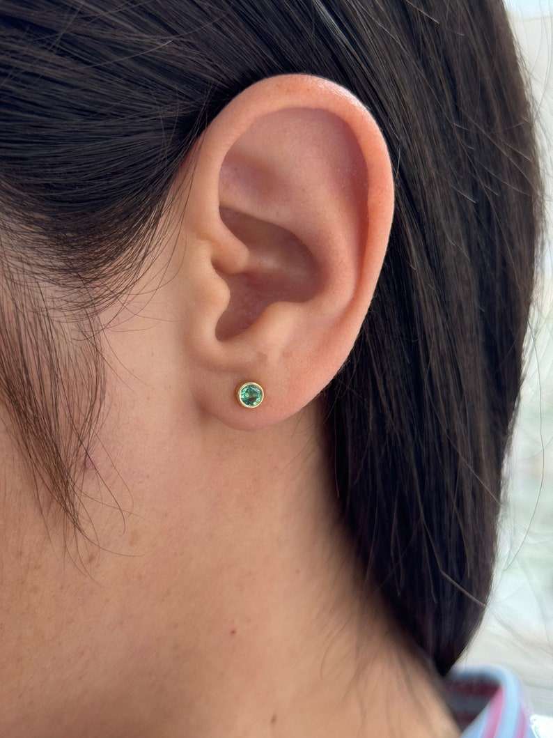 Colombian Emerald 14K yellow gold earrings with 0.50tcw natural lush medium green round-cut bezel-set gemstones.
