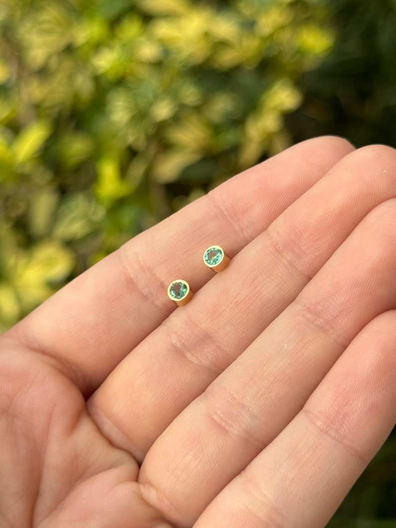 Colombian Emerald 14K yellow gold earrings with 0.50tcw natural lush medium green round cut bezel-set gemstones.
