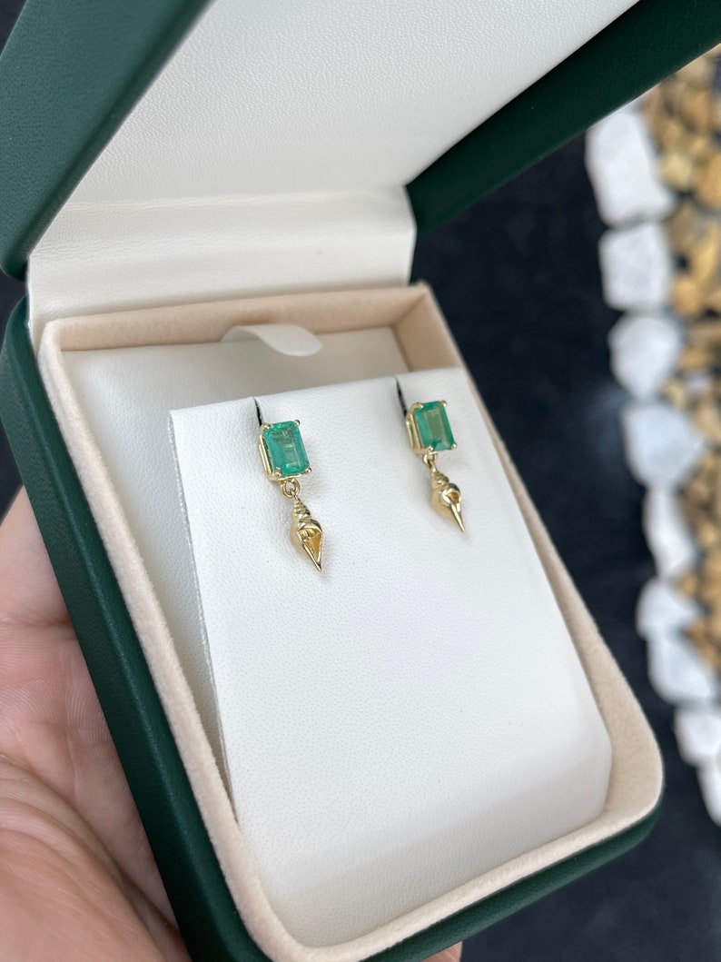 Colombian Emerald 14K gold dangle earrings with natural emerald and tuba sea shell accents, showcasing elegant jewelry design.