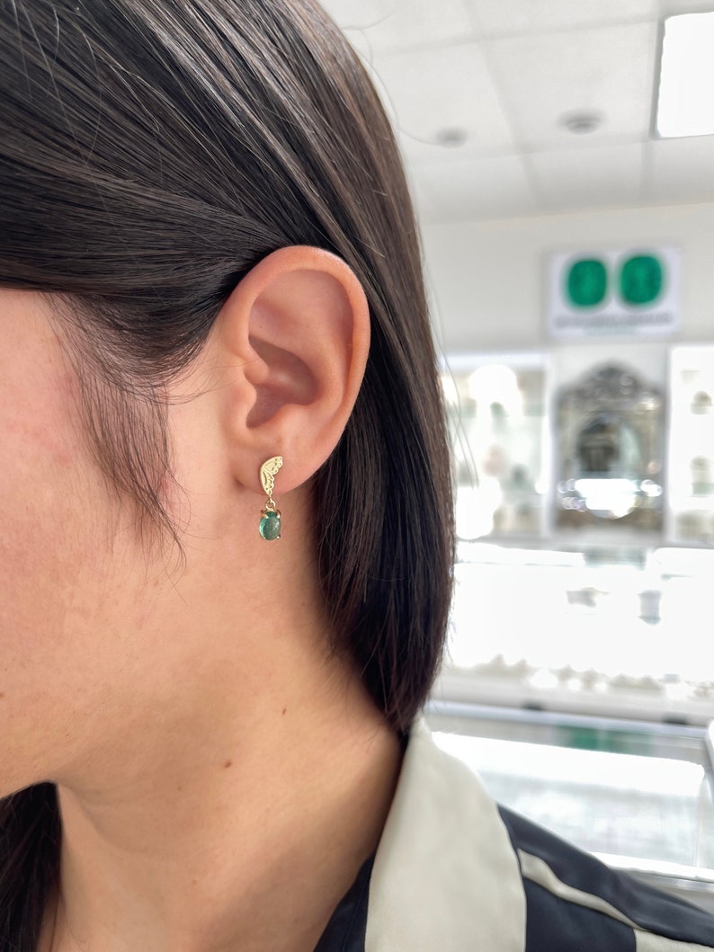 14K green emerald cabochon oval dangle earrings with half butterfly design, featuring Colombian Emerald branding and elegant craftsmanship.