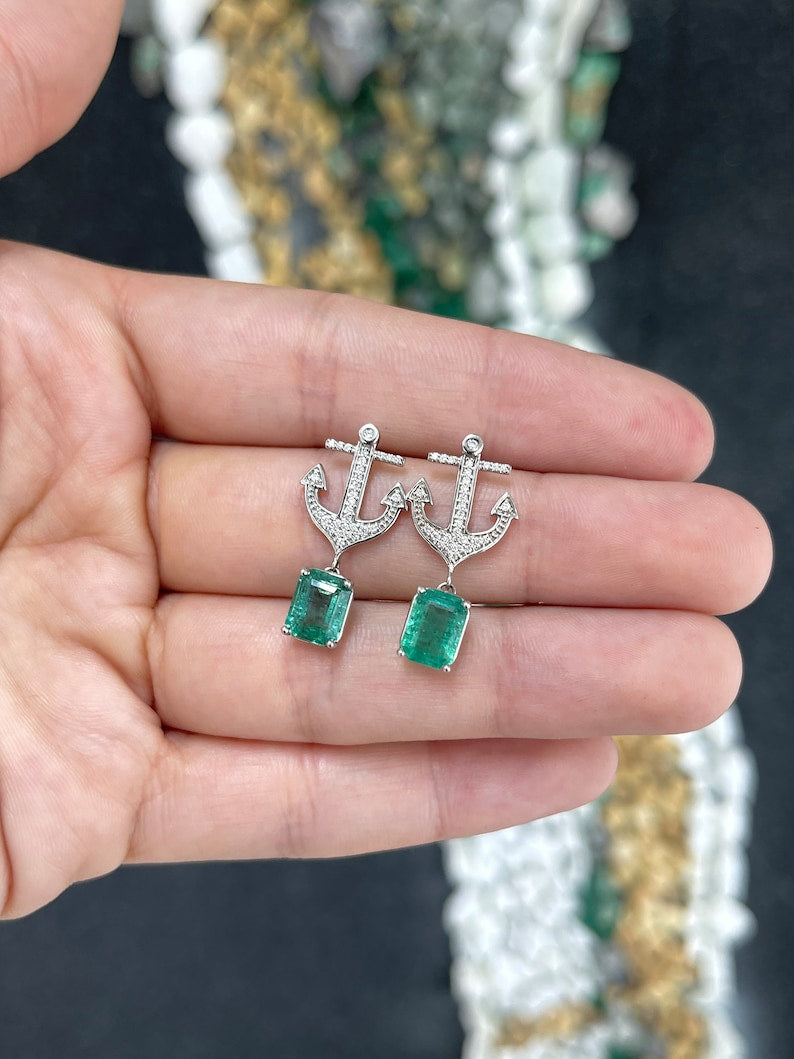 14K gold emerald and diamond anchor dangle earrings featuring lush green emeralds and sparkling diamonds.