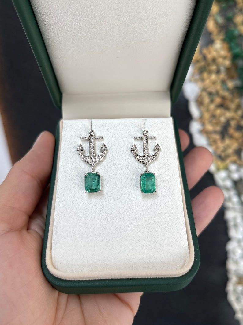 14K gold emerald and diamond anchor dangle earrings featuring lush green emeralds and sparkling diamonds.