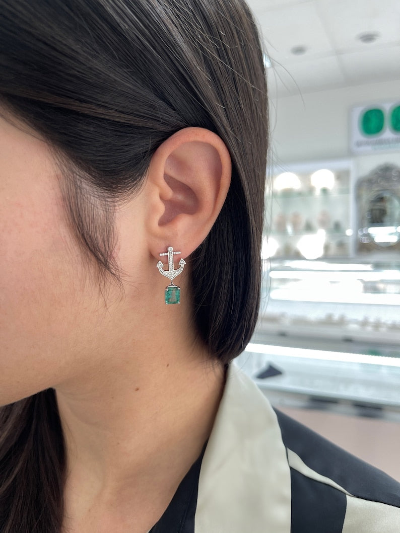 14K yellow gold emerald and diamond anchor dangle earrings with lush green emeralds and sparkling diamonds.
