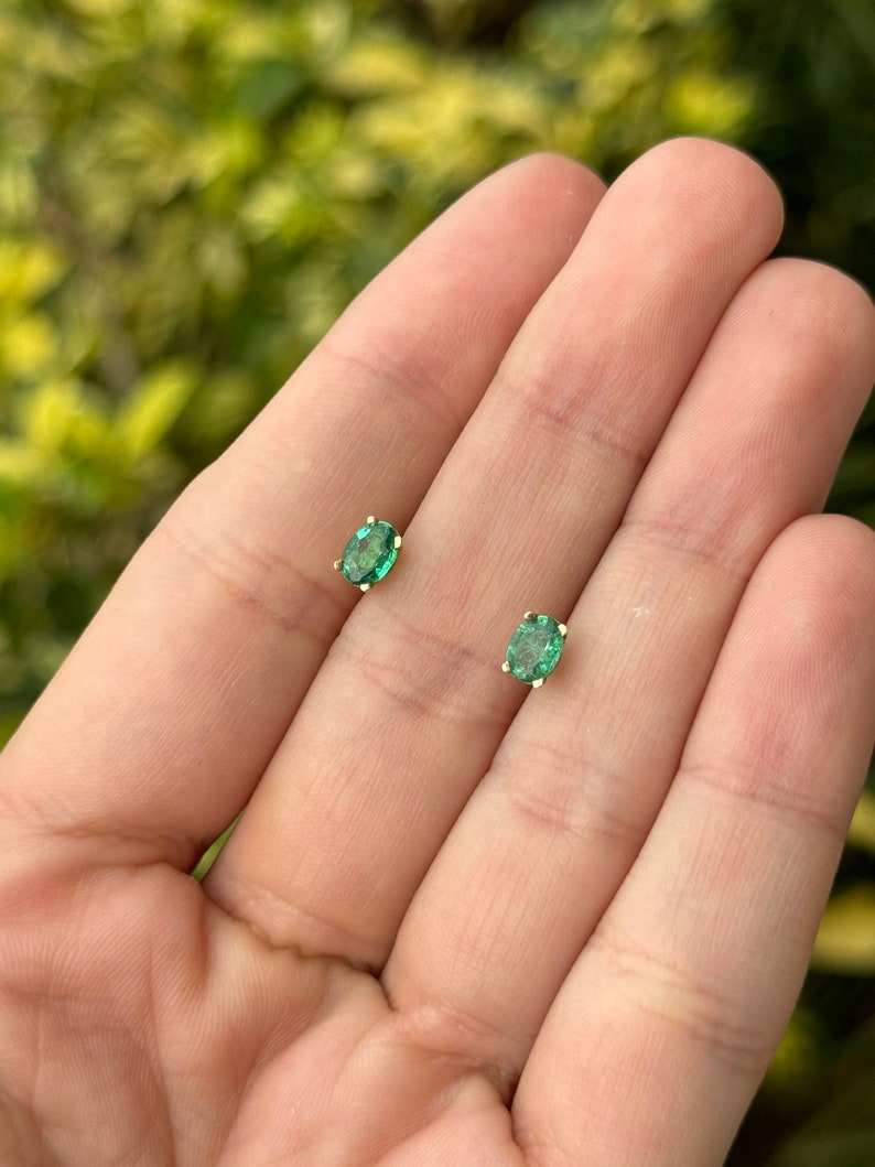14K green emerald children’s stud earrings with petite oval cut and four-prong setting from Colombian Emerald brand.