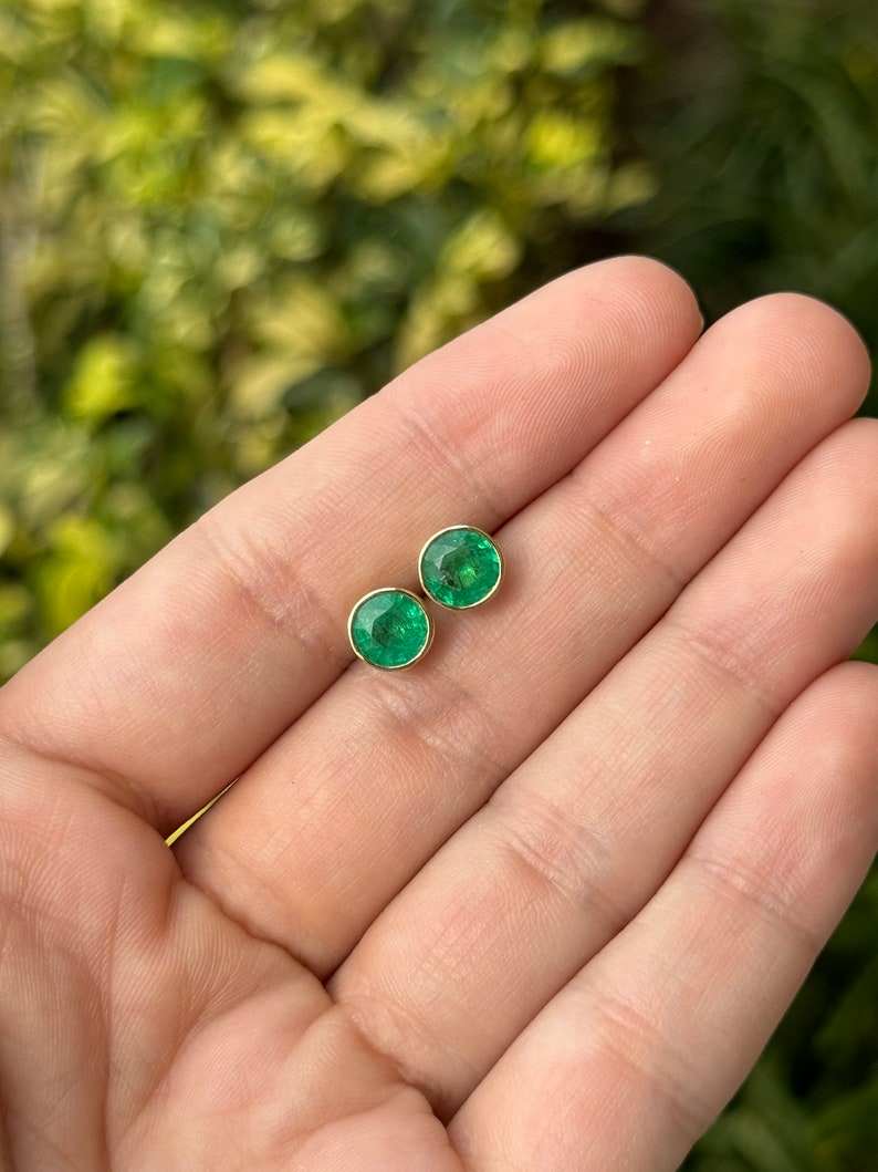 Colombian Emerald 18K gold round cut vivid green bezel set with window stud earrings showcasing sparkling emerald gemstones.