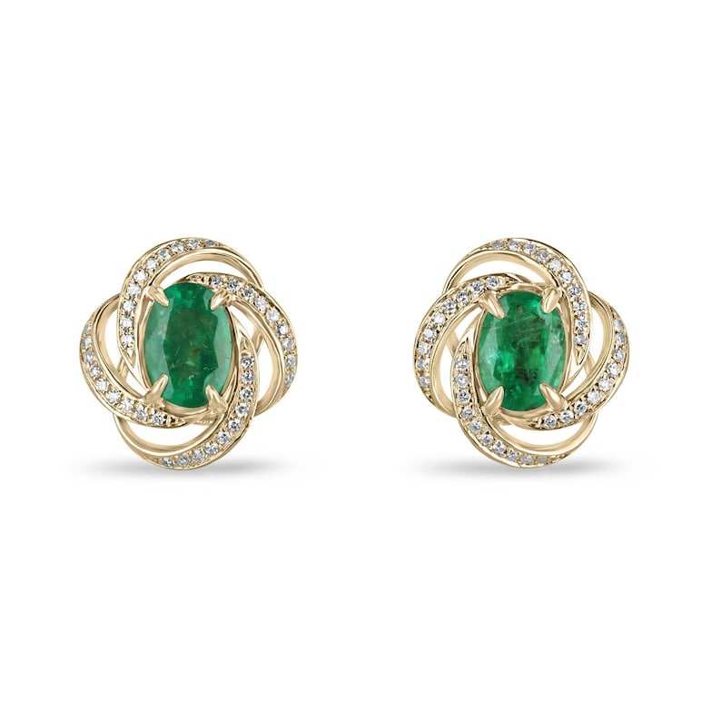 14K gold earrings with medium dark green oval cut emeralds and diamond swirl halo design
