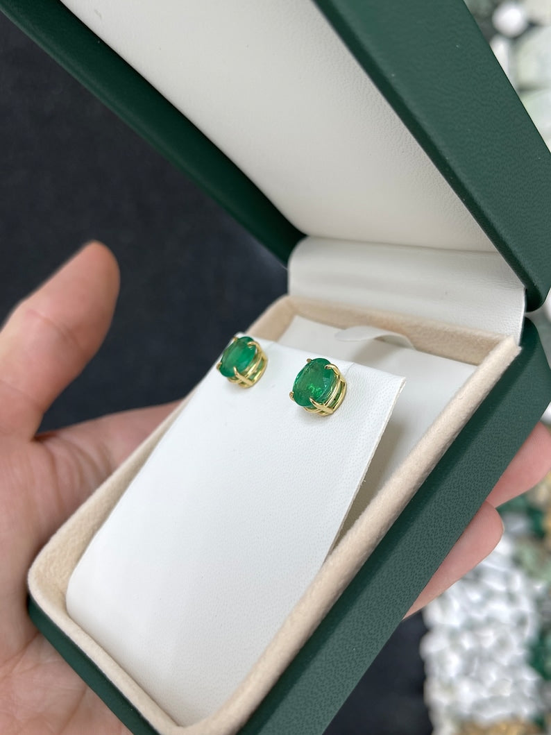 Colombian Emerald earrings with oval cut dark green emeralds set in 18K gold four-prong claw studs, 4.85tcw total weight.