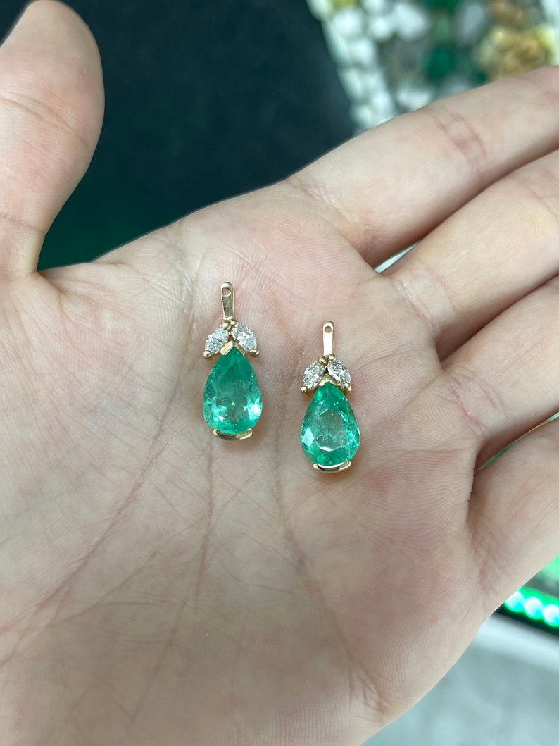 Colombian Emerald earrings with 7.97tcw pear-cut green teardrop emeralds and marquise diamonds in floral earring jackets.
