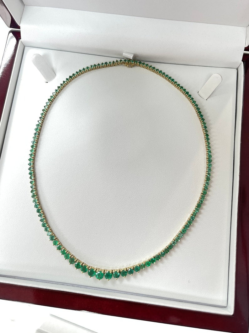 Colombian Emerald 22.0 tcw 14K yellow gold graduating round chain tennis necklace with vivid medium dark green emeralds.