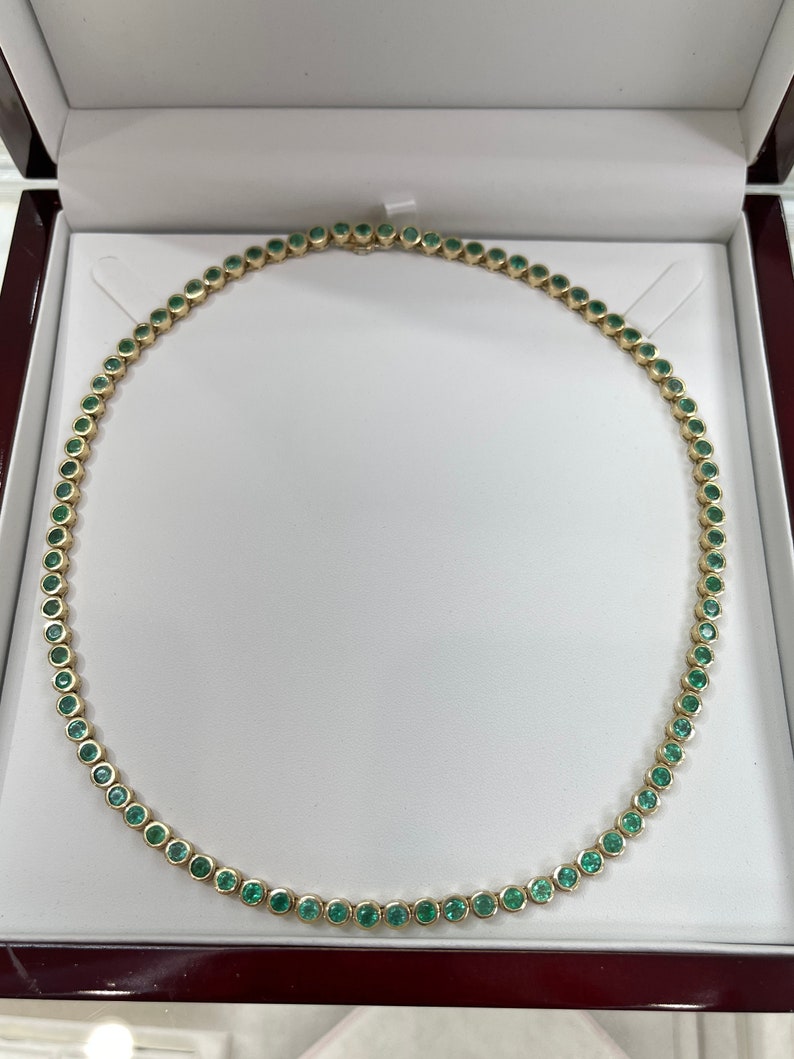 Medium green emerald bezel tennis necklace with 25.50 carats from Colombian Emerald, featuring round natural stones in 14K gold.