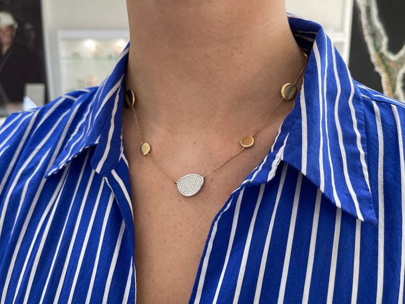 Emerald necklace with a cluster of diamonds on a 14K white and yellow gold cable chain, featuring a semi-circle design.