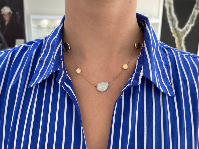 14K gold diamond cluster necklace featuring a semi-circle design with round cut diamonds and emerald accents.