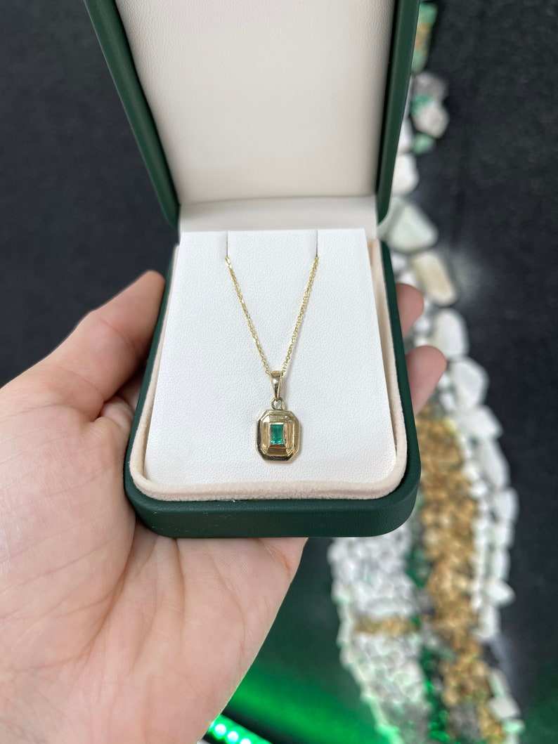 14K gold unisex pendant necklace with a lush green natural emerald cut gemstone bezel set, Colombian Emerald brand.