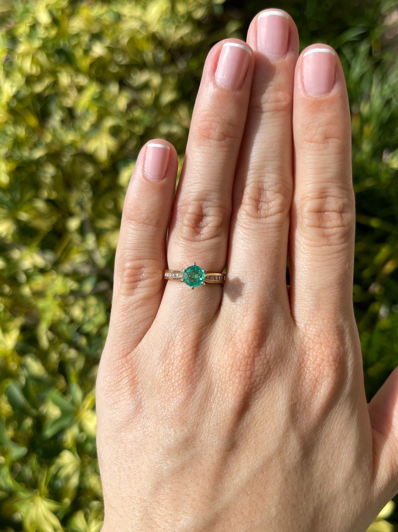 Two-toned 14K emerald and diamond accent engagement ring with round cut center stone and six-prong setting by Colombian Emerald