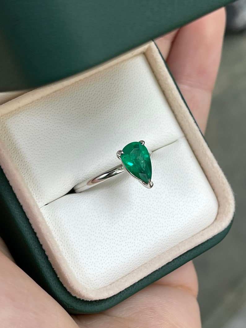 Colombian Emerald 1.28ct AAA pear cut engagement ring with 3 prongs in 18K white gold, showcasing a sparkling emerald gemstone.