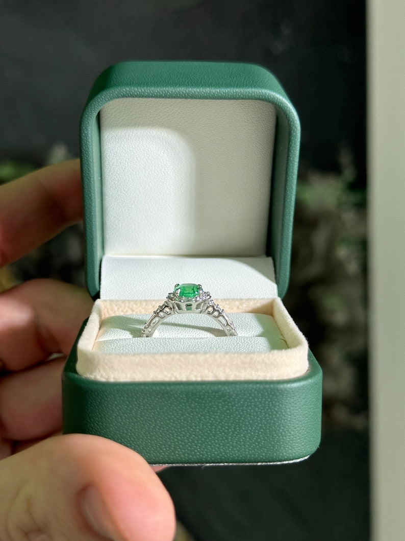 Colombian Emerald engagement ring featuring a 1.55tcw vivid green cushion cut emerald with diamond halo and baguette accents in 14K gold